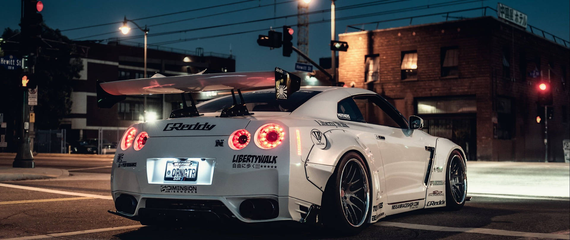 夜間停泊在城市街道十字路口的白色改裝日產GT-R。