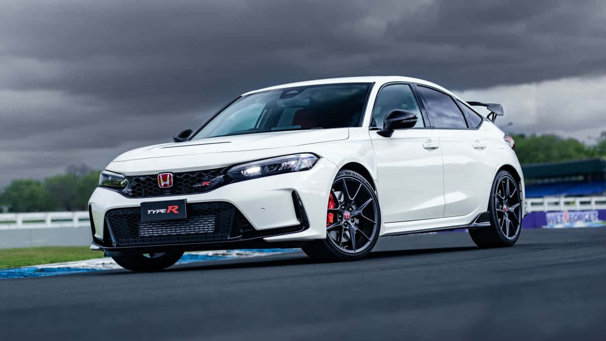 桌布 壁紙 — 一輛白色本田 Type R 跑車，配備黑色輪圈和紅色制動卡鉗，在暴風雨天空下的賽道上蓄勢待發。