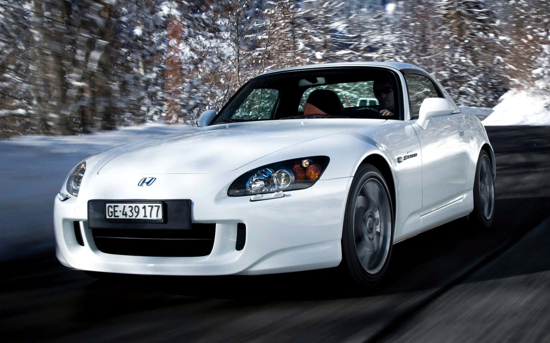 Honda S2000 桌布 壁紙 — 一輛白色本田S2000跑車在積雪的森林道路上高速行駛，帶有動態模糊效果。