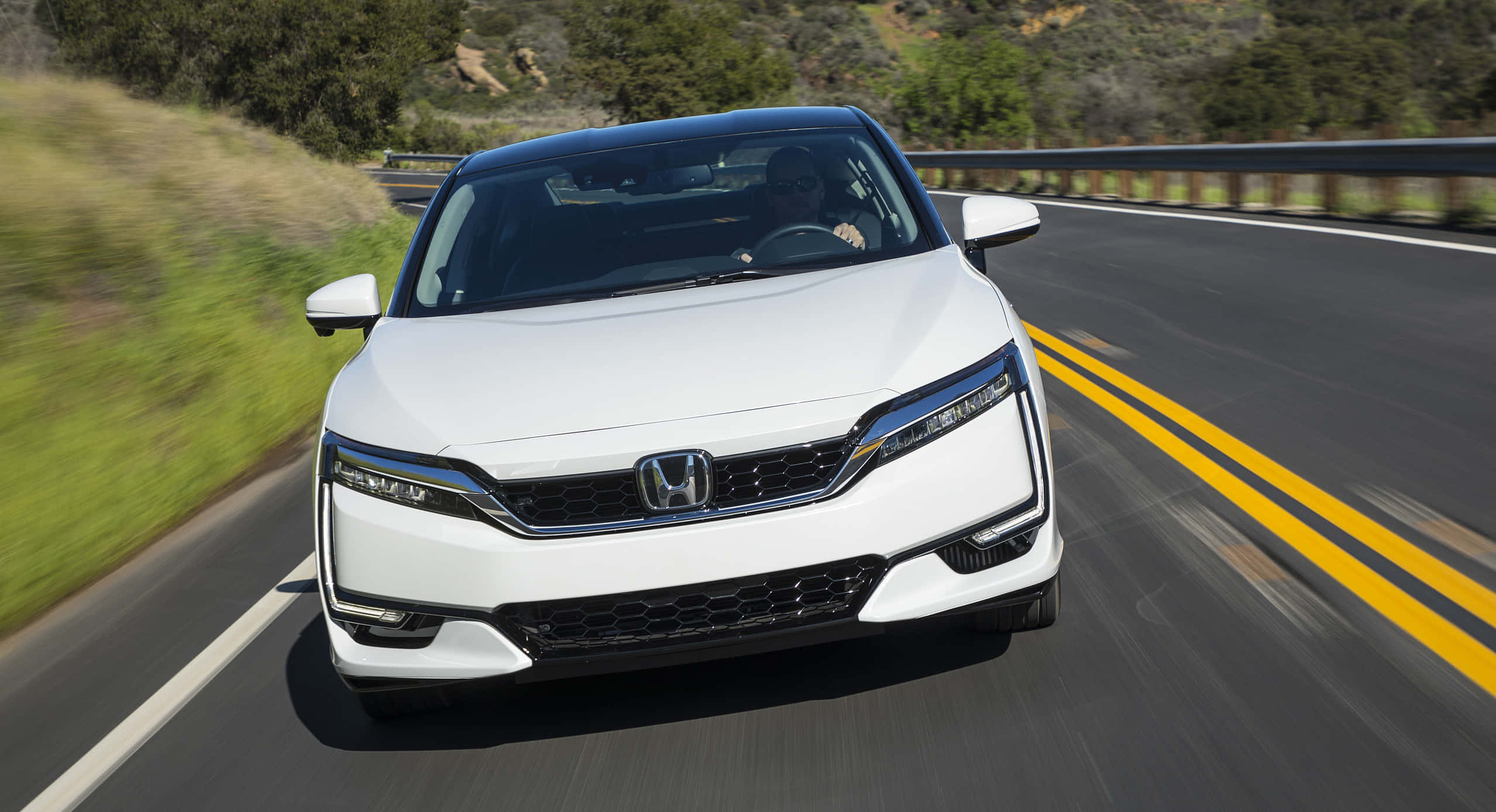Honda Clarity 桌布 壁紙 — 一輛白色本田轎車沿著蜿蜒的山路疾馳，周圍是模糊的綠植和黃色車道標線。