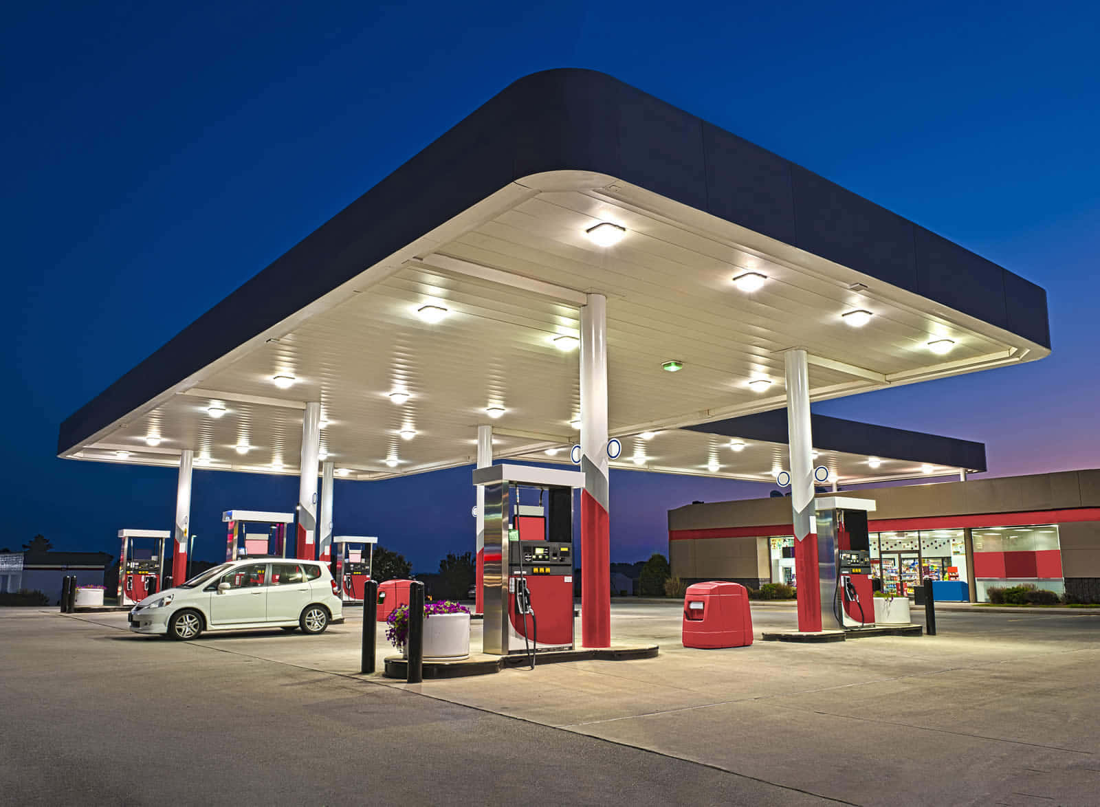 Petrol Station 桌布 壁紙 — 一輛白色汽車停在光線明亮的加油站頂篷下，背景是深藍色的暮色天空。