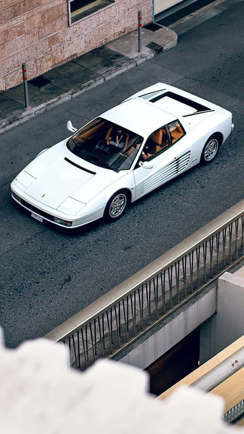 white ferrari 桌布 壁紙 — 一輛白色法拉利348在混凝土高架橋下的城市街道上優雅地行駛。