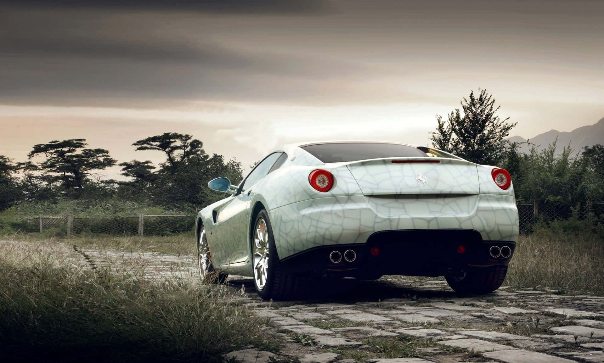 Ferrari 599 Gtb Fiorano 桌布 壁紙 — 一輛白色法拉利跑車帶有裂紋油漆，停泊在鄉間田野的石徑上，天空多雲。