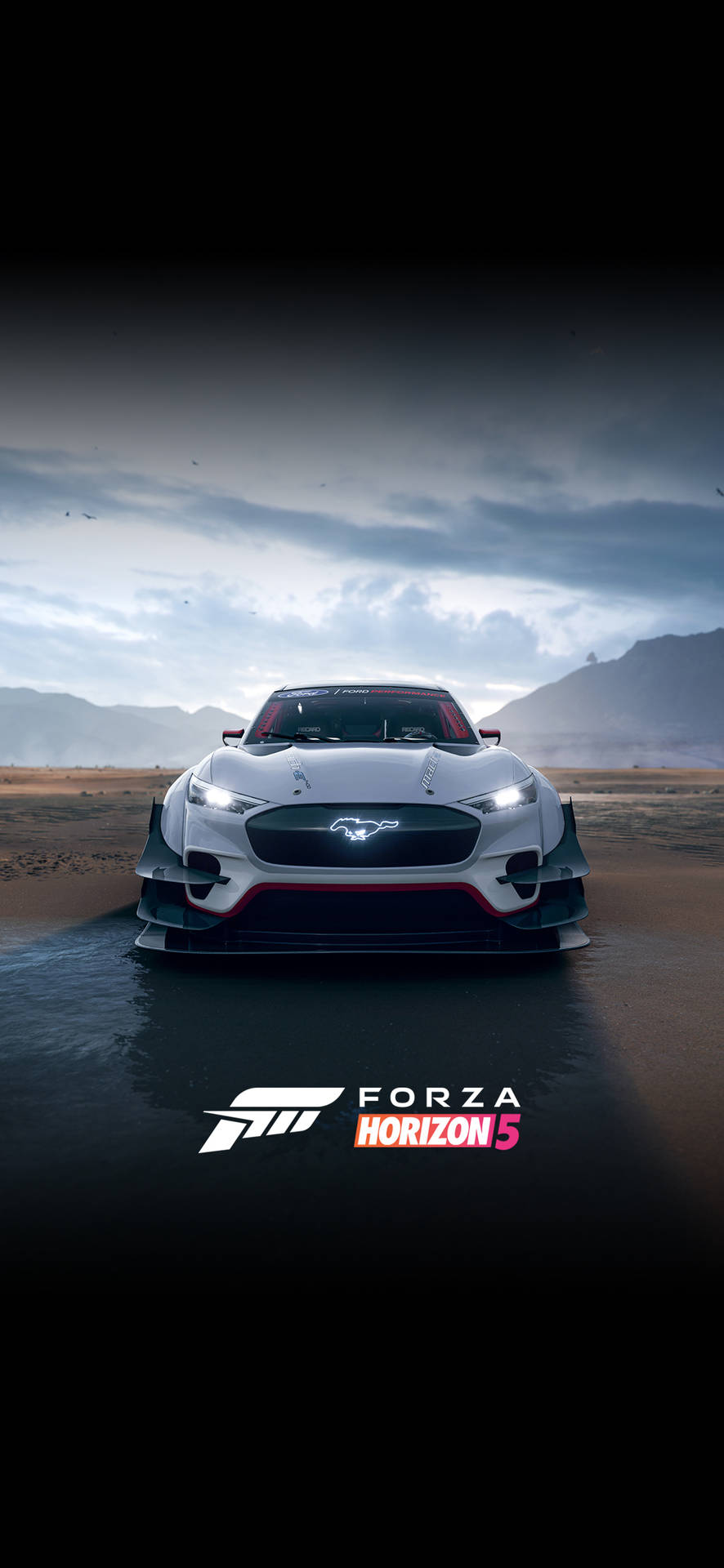 Mustang 桌布 壁紙 — 一輛白色福特野馬GT350R賽車，車頭燈閃閃發光，停在一條濕漉漉的沙漠公路上，背景是戲劇性的多雲天空和遠處的山脈。