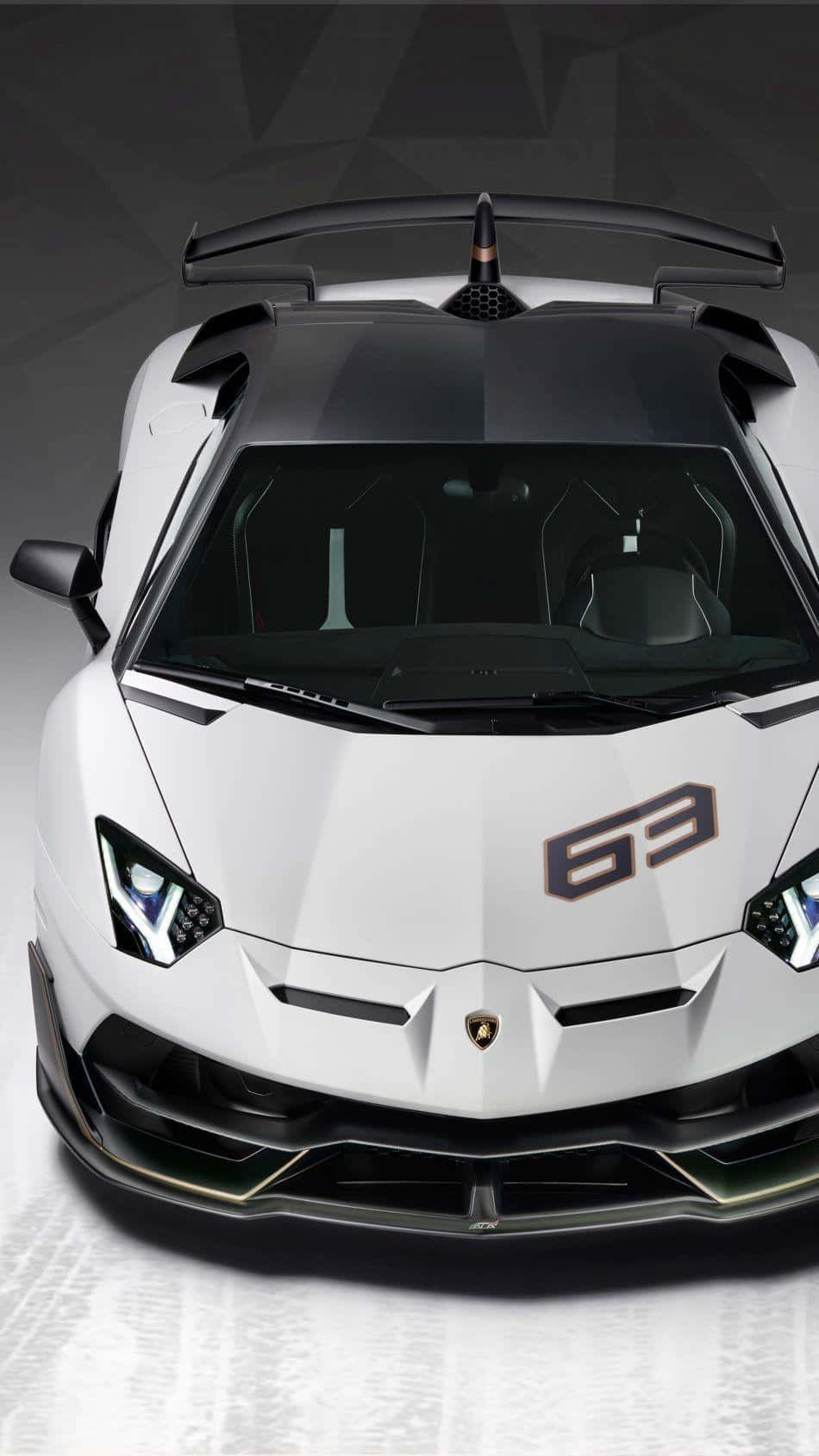 Lamborghini Phone 桌布 壁紙 — 一輛白色藍寶堅尼 Aventador SVJ，帶有黑色飾邊和「63」徽章，從上方俯瞰，背景為幾何灰色。