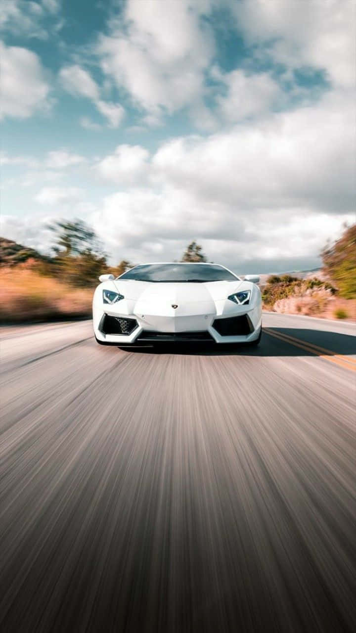 race car 桌布 壁紙 — 一輛白色藍寶堅尼Aventador在部分多雲的天空下，沿著蜿蜒的道路高速行駛，帶有模糊的動態效果。
