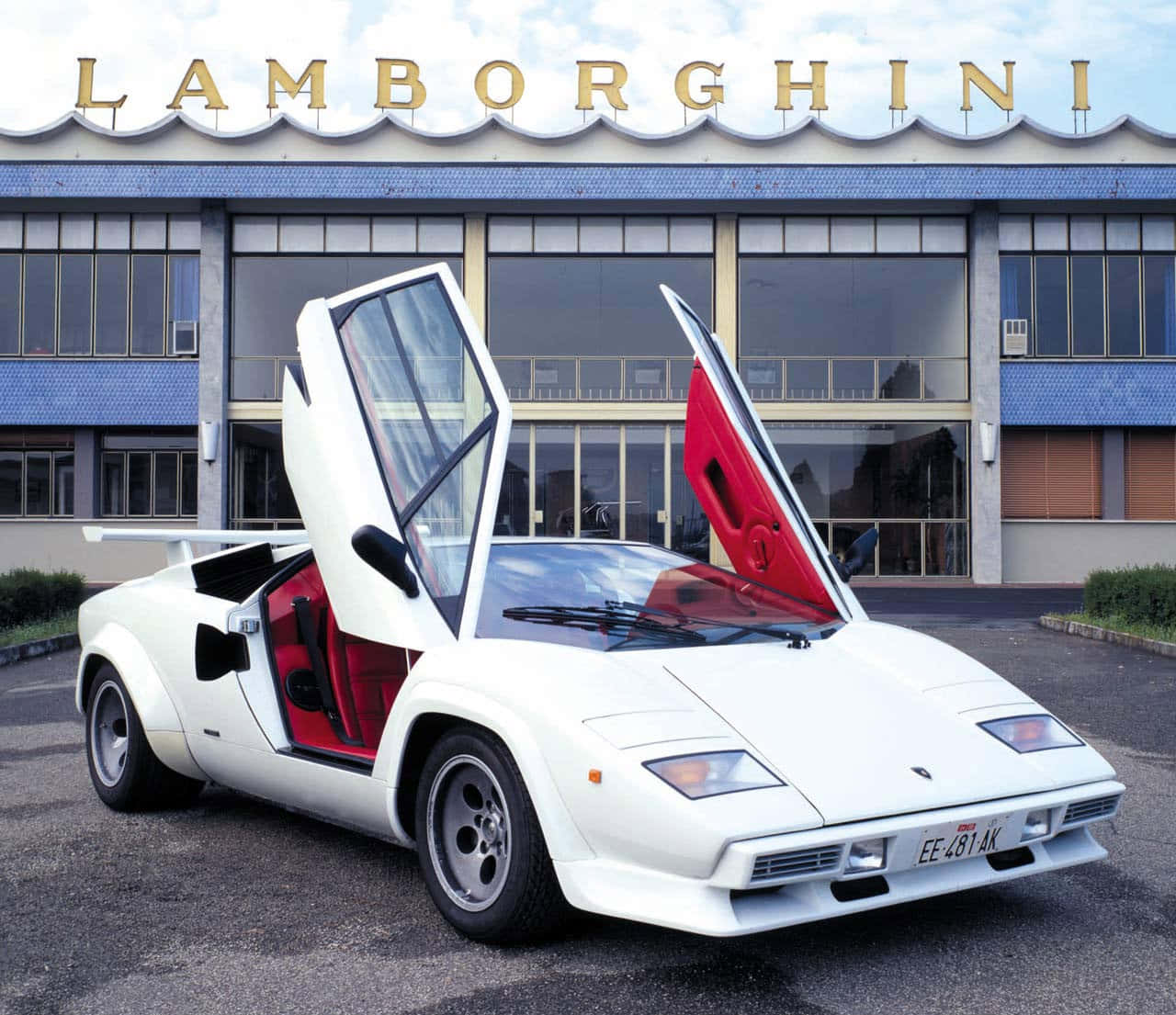 Lamborghini Countach 桌布 壁紙 — 一輛白色藍寶堅尼Countach搭配紅色內裝，剪刀門開啟，停在藍寶堅尼工廠大樓前。