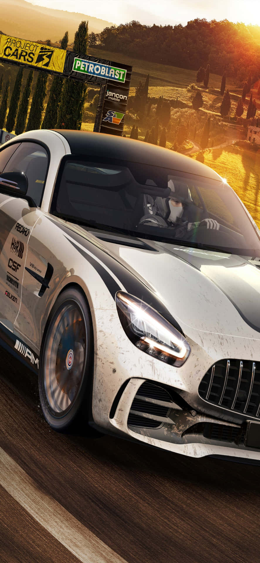 白色賽車在金色日落下的泥濘賽道上飛馳，帶有贊助商橫幅。 — Project Cars 壁紙