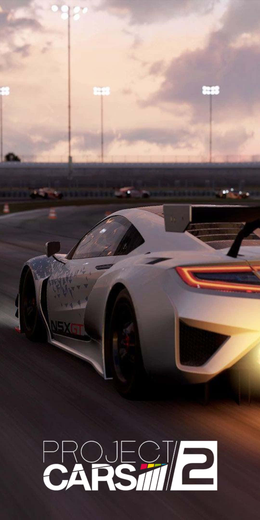 Pixel 3 Project Cars 2 桌布 壁紙 — 一輛白色賽車在黃昏時分沿著賽道飛馳，上方體育場的燈光閃爍。