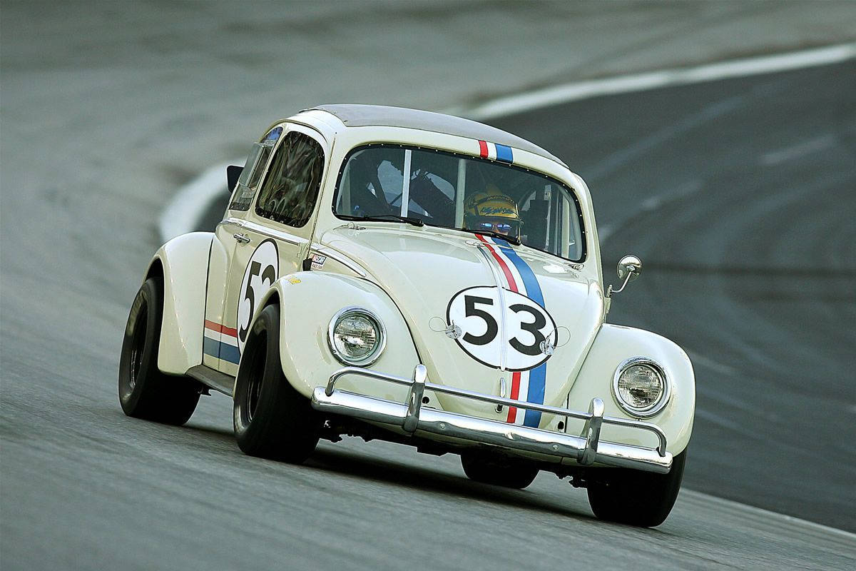 Herbie 桌布 壁紙 — 一輛白色賽車改裝福斯金龜車，編號53，在灰色瀝青賽道上奔馳。