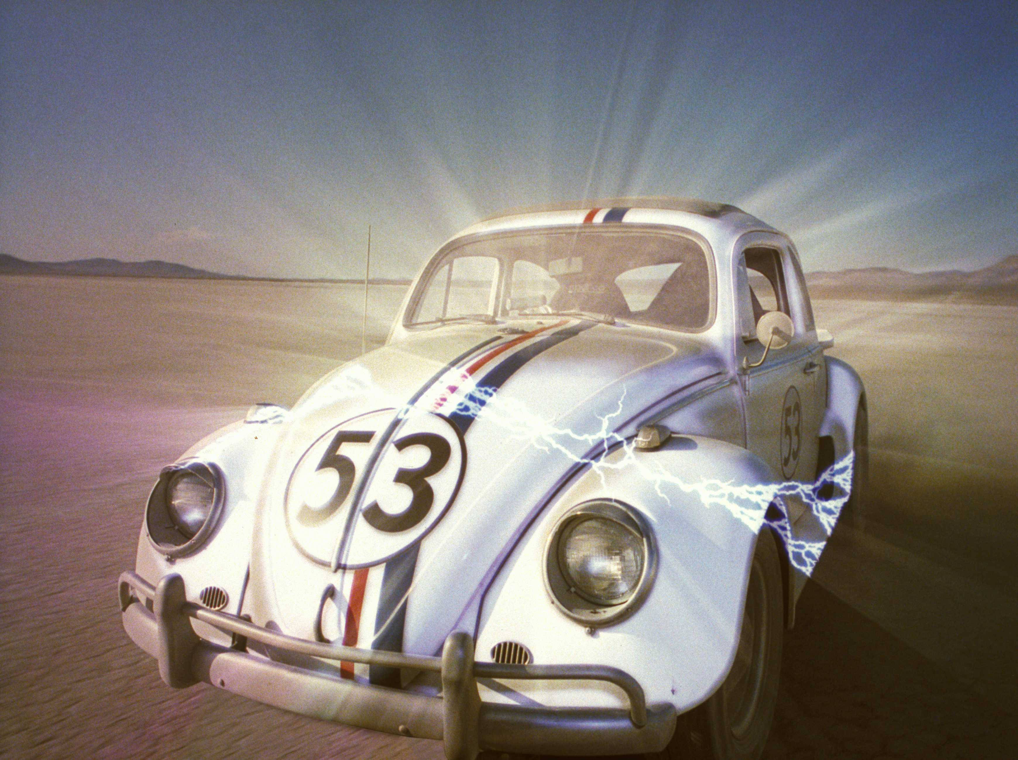 Herbie 桌布 壁紙 — 一輛白色賽車改裝福斯金龜車（編號53）在電光閃爍的烈日下飛馳過沙漠。