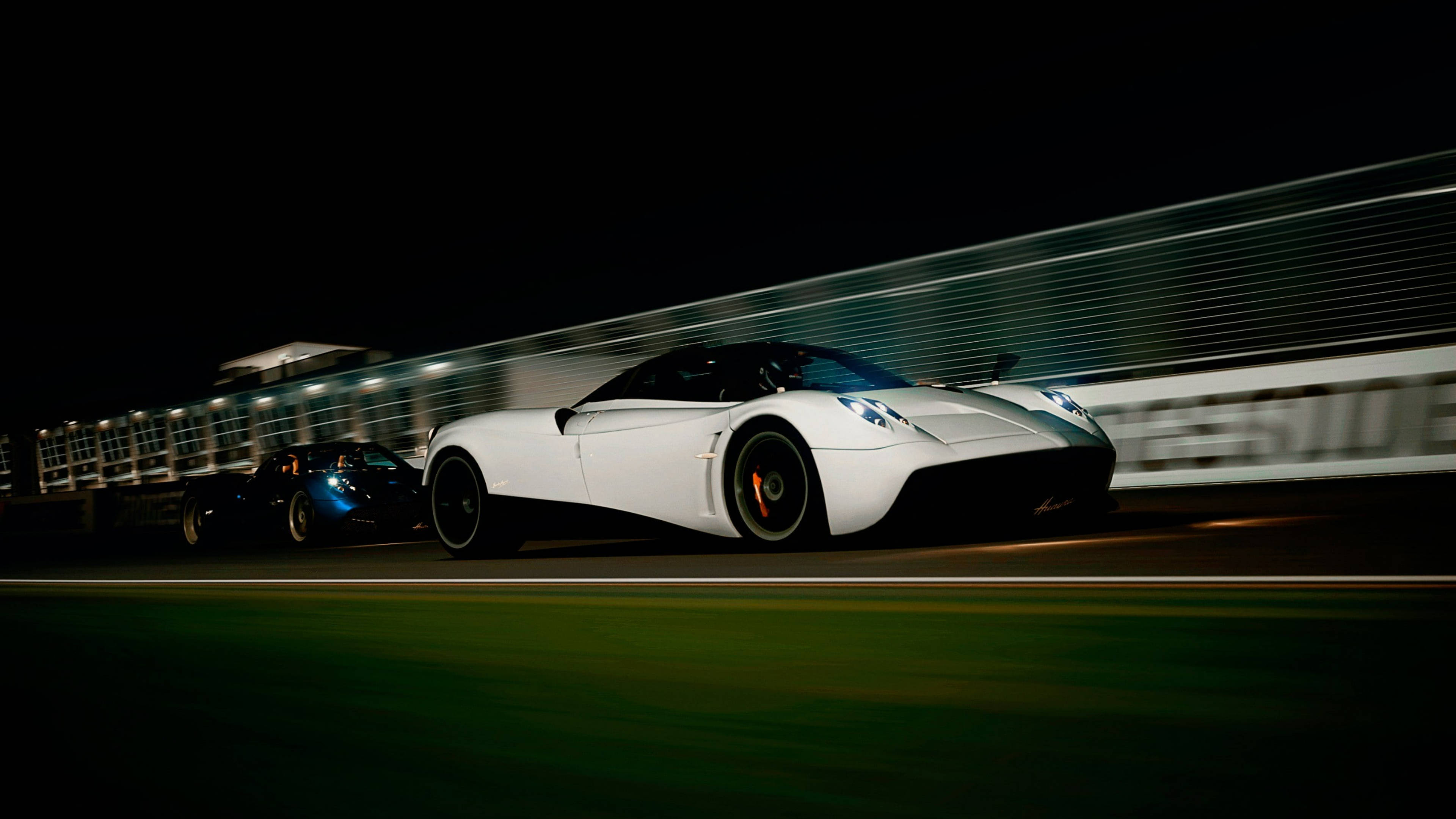 Pagani 桌布 壁紙 — 一輛白色超跑在夜間賽道上疾馳，帶有動態模糊效果。