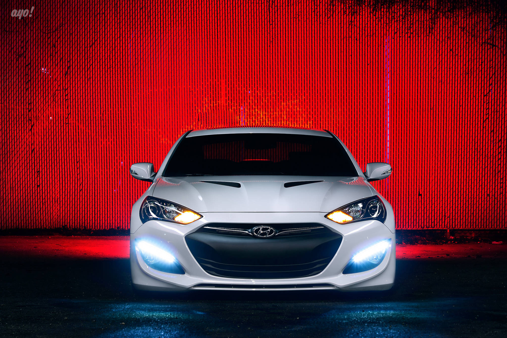 Hyundai 桌布 壁紙 — 一輛白色跑車亮著車頭燈，正面對著一面鮮紅色紋理牆壁，地面有藍色水坑倒影。