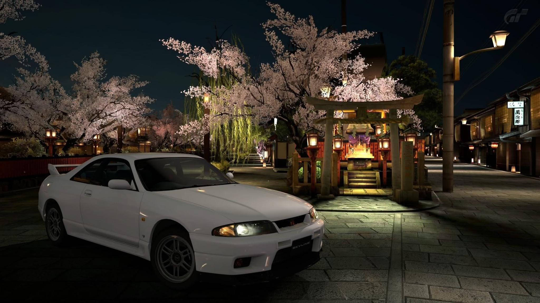 Gtr 桌布 壁紙 — 一輛白色跑車在夜晚的街燈下，在一個寧靜的日本小鎮的櫻花神社旁閃耀。