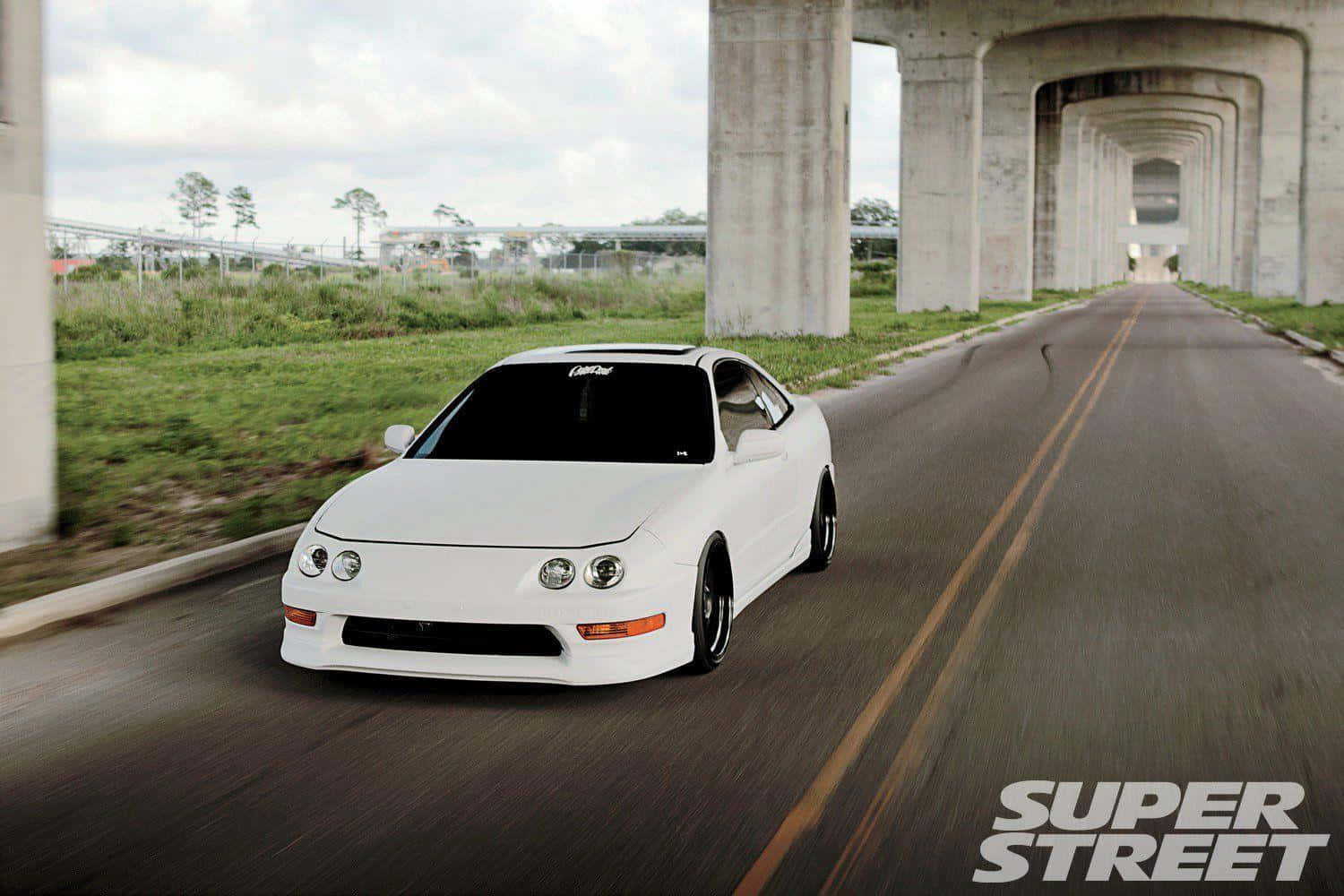 Acura Integra 桌布 壁紙 — 一輛白色跑車在混凝土天橋下高速行駛，道路上呈現動態模糊效果。