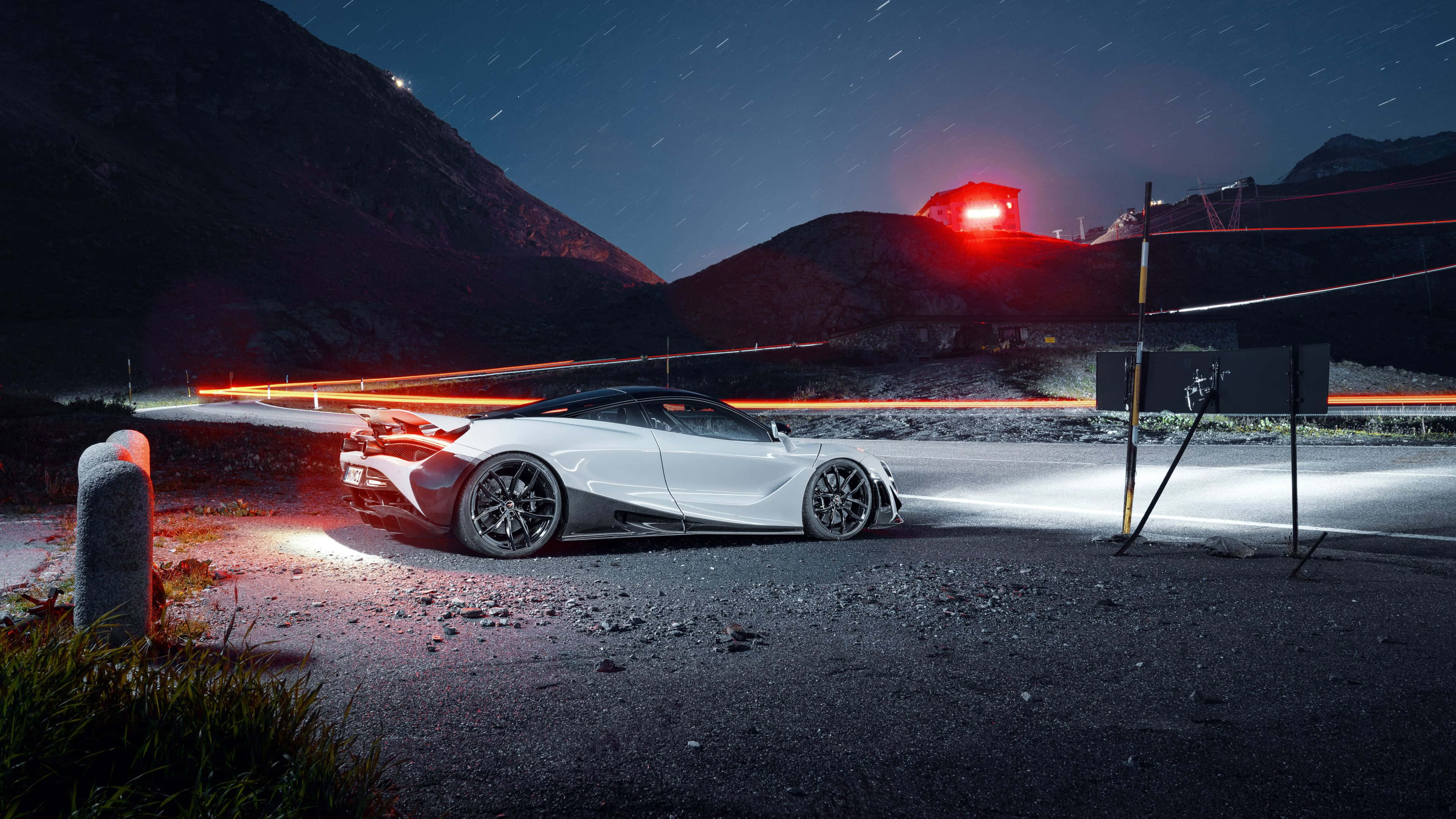 4K Mclaren 720s 桌布 壁紙 — 一輛白色跑車夜間停在山路上，伴隨星軌和過往車輛的紅色光痕。