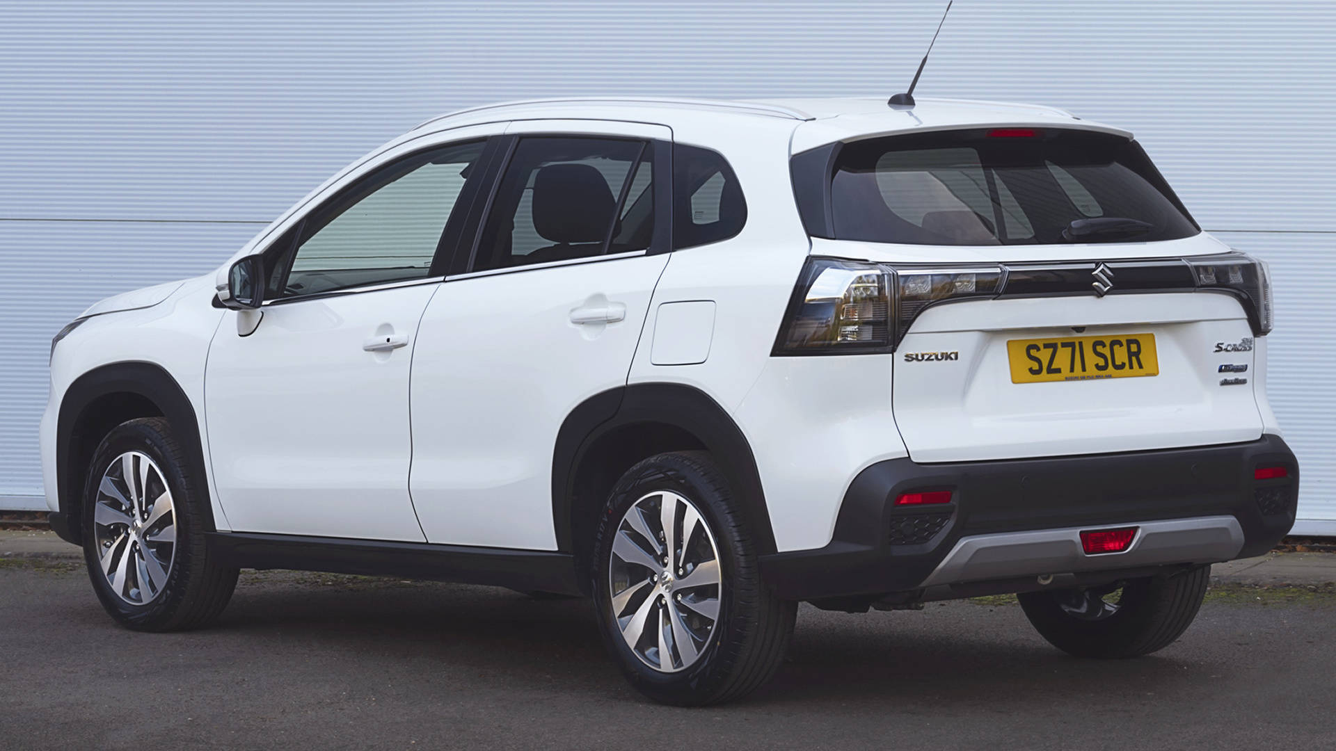 Suzuki 桌布 壁紙 — 一輛白色鈴木 S-Cross SUV 以傾斜角度停放在淺灰色波紋牆前，車牌清晰可見。