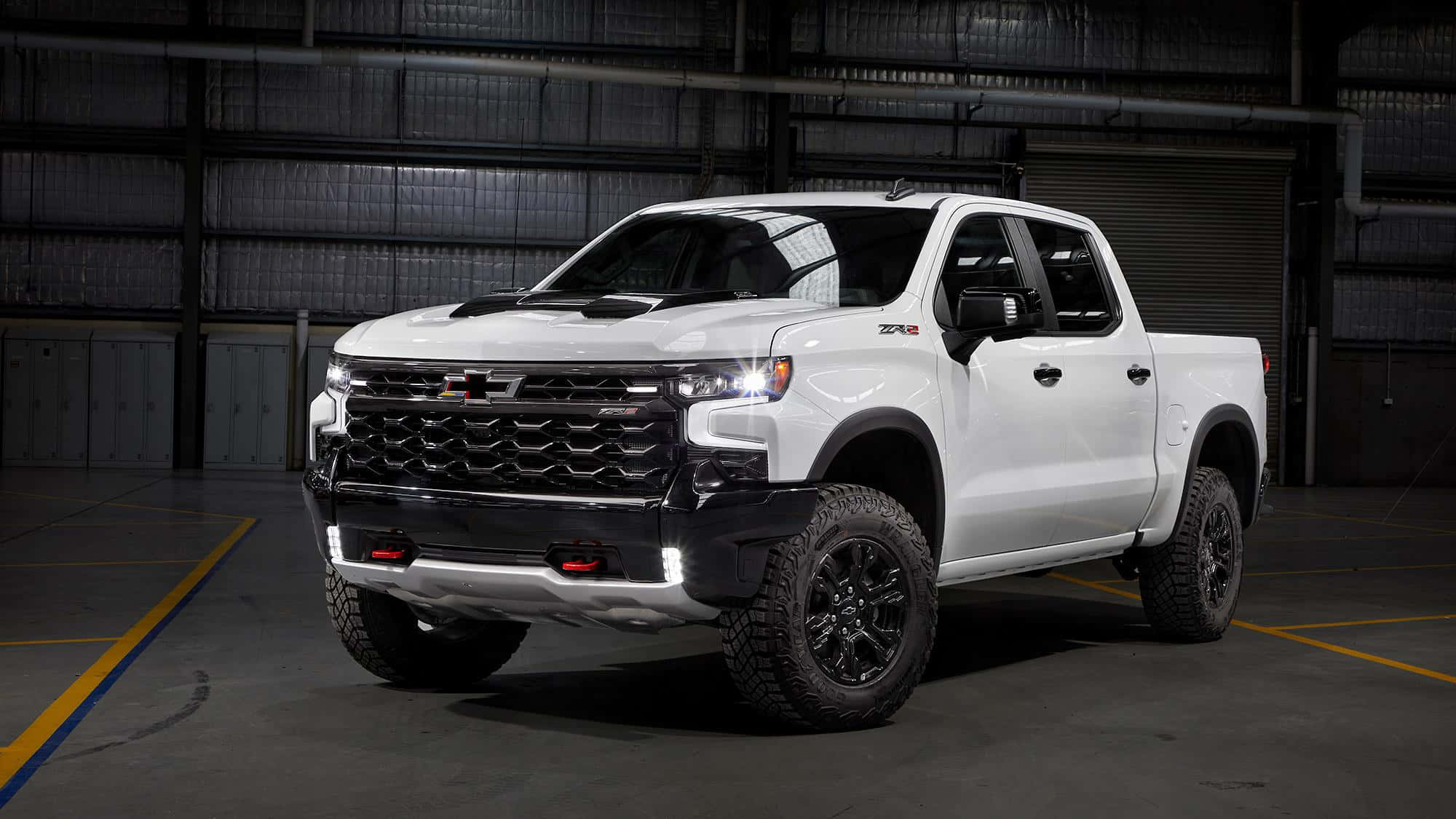 Chevrolet 桌布 壁紙 — 一輛白色雪佛蘭ZR2皮卡車，帶有黑色飾邊和堅固輪胎，停放在光線昏暗的工業倉庫內。