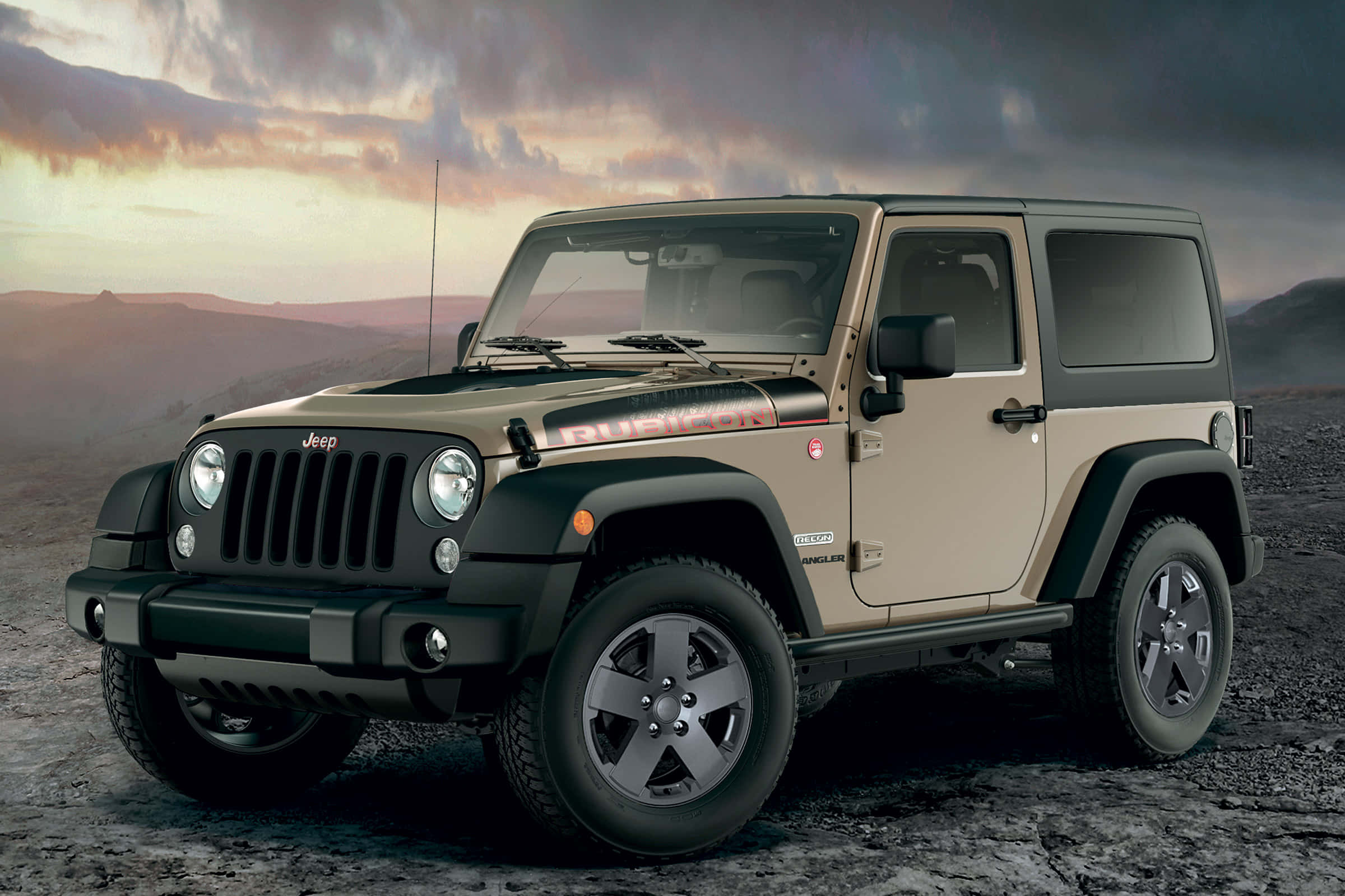 Jeep Wrangler 桌布 壁紙 — 一輛米色和黑色的Jeep Wrangler在紫色和橙色雲彩的戲劇性日落天空下，堅固地矗立在岩石地形上。