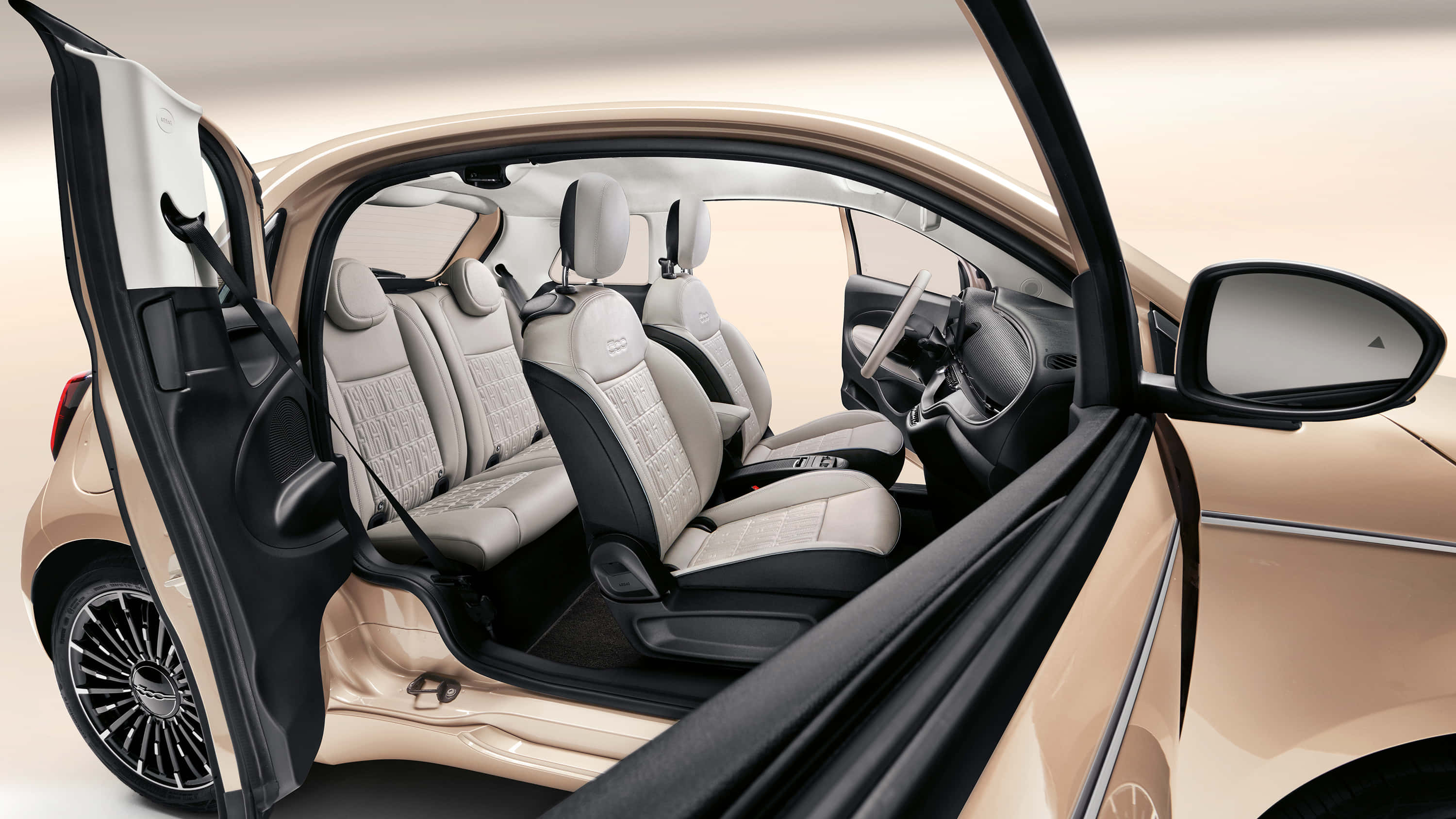 Fiat 桌布 壁紙 — 一輛米色緊湊型汽車，車門打開，露出淺灰色絎縫座椅和黑色裝飾，在工作室環境中。