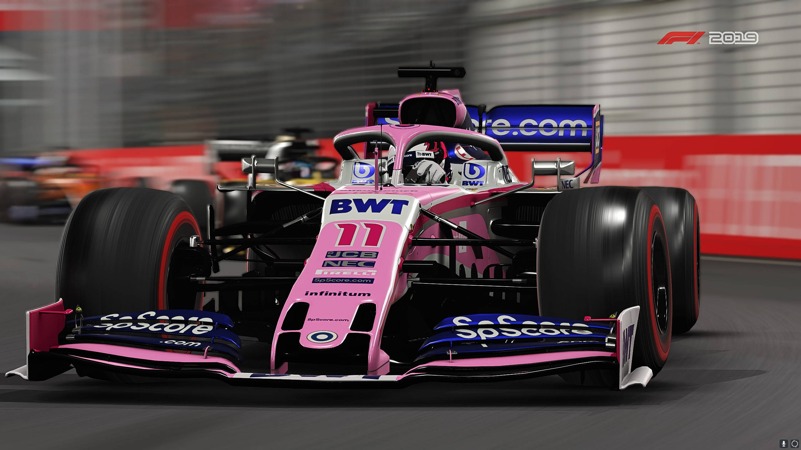 F1 2019 壁紙 桌布 壁紙 — 一輛粉紅色和藍色的 Formula 1 賽車，號碼 11，在賽道上疾馳，背景呈現模糊動態。