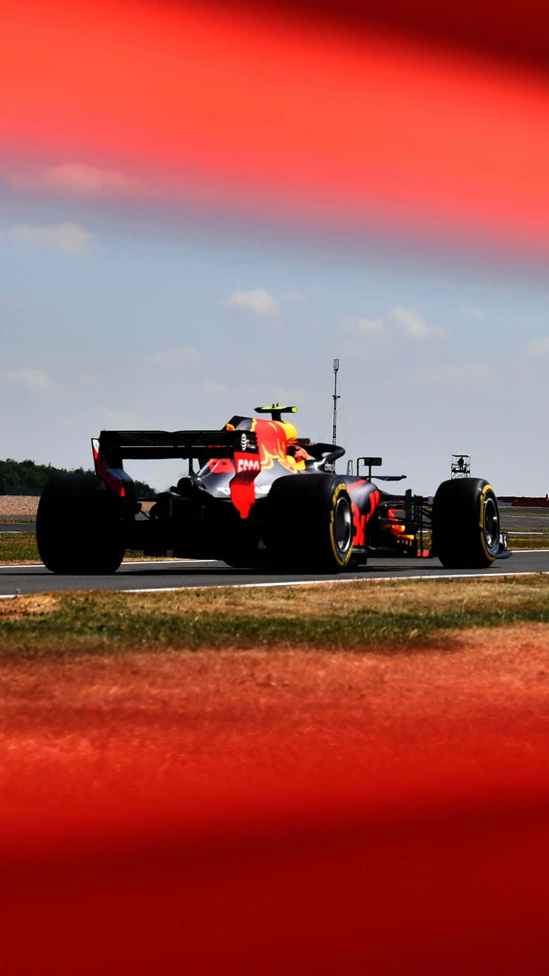 F1 2016 桌布 壁紙 — 一輛紅牛一級方程式賽車在戲劇性的紅藍天空下沿著賽道飛馳。