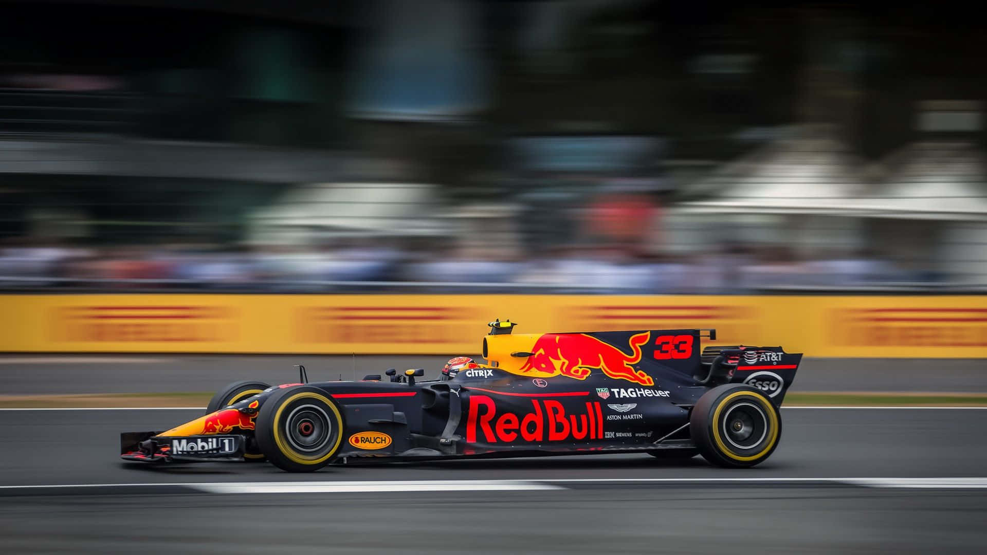 Max Verstappen 桌布 壁紙 — 一輛紅牛一級方程式賽車在明亮的日光下，在賽道上以動態模糊效果疾馳而過。