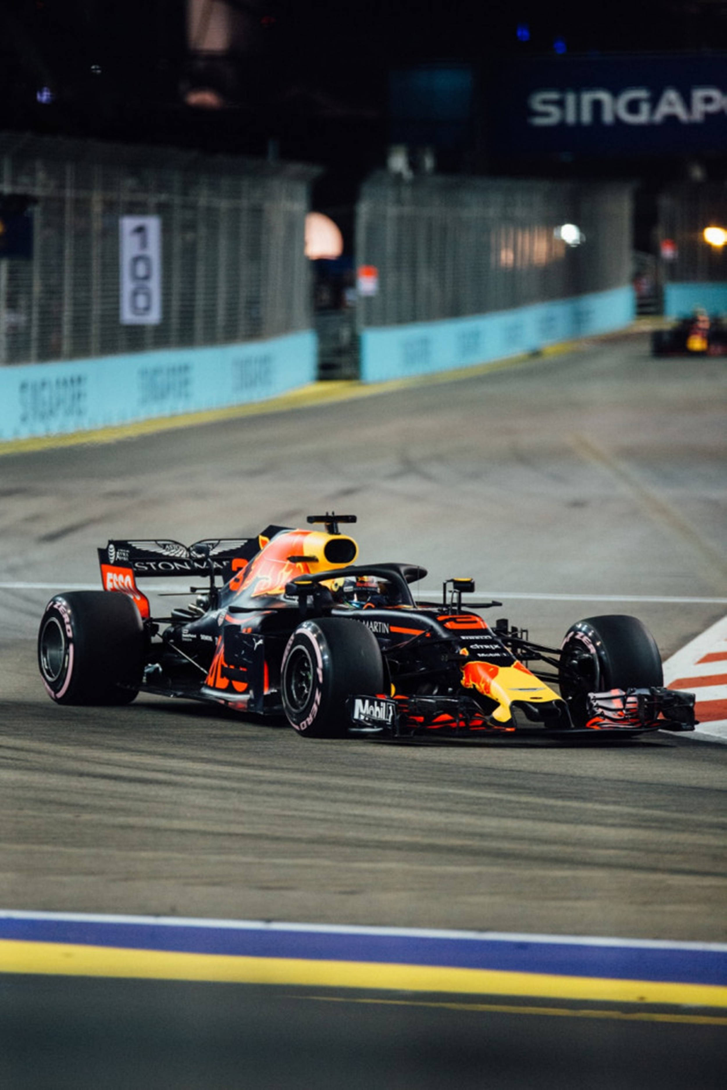 F1 桌布 壁紙 — 一輛紅牛一級方程式賽車在明亮的賽道燈光下，於夜間的新加坡街道賽道上飛馳。