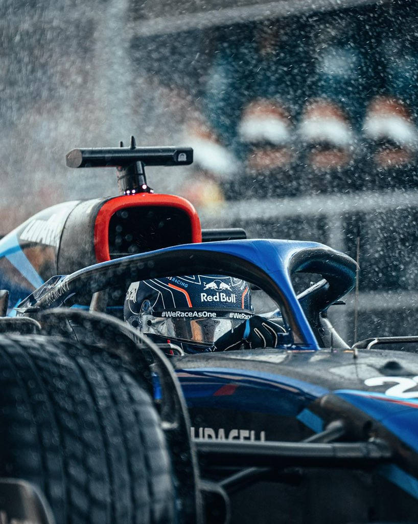 F1 桌布 壁紙 — 一輛紅牛一級方程式賽車在暴雨中疾馳，車手專注於駕駛艙內。