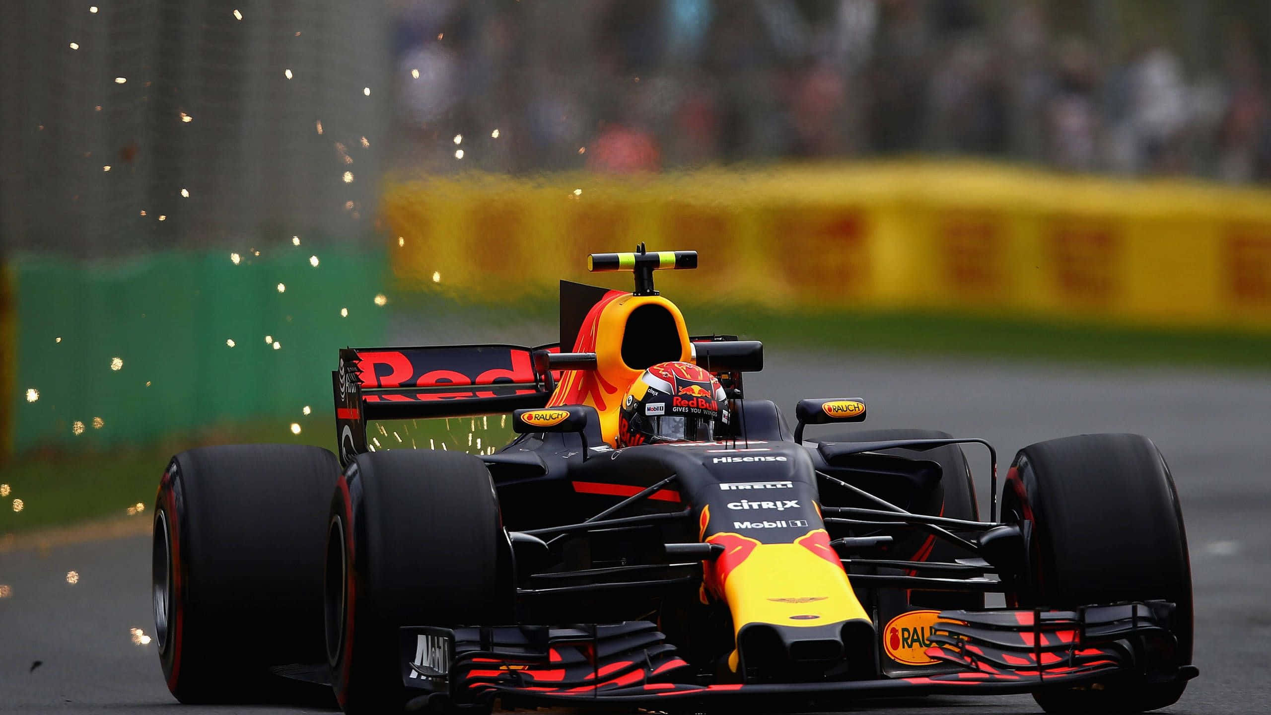 Max Verstappen 桌布 壁紙 — 一輛紅牛一級方程式賽車在賽道上疾馳，車尾火花四濺，車手飛馳而過模糊的看台。
