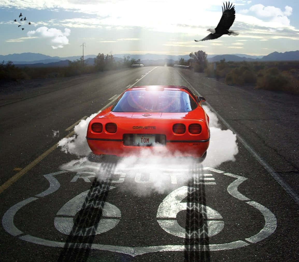 C4 Corvette 桌布 壁紙 — 一輛紅色Corvette在66號公路上飄移，留下煙霧，一隻鷹在沙漠天空中翱翔。
