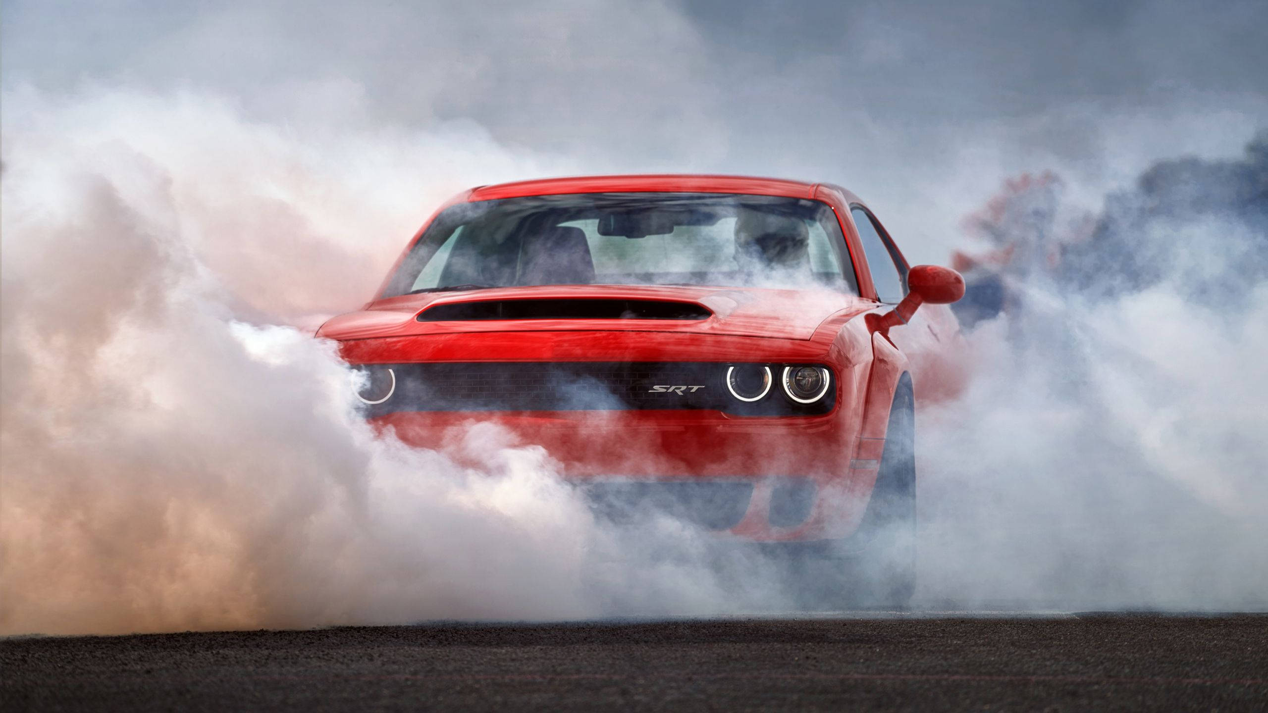 Challenger 桌布 壁紙 — 一輛紅色Dodge Challenger SRT在深色瀝青賽道上進行戲劇性的燒胎，揚起濃煙。