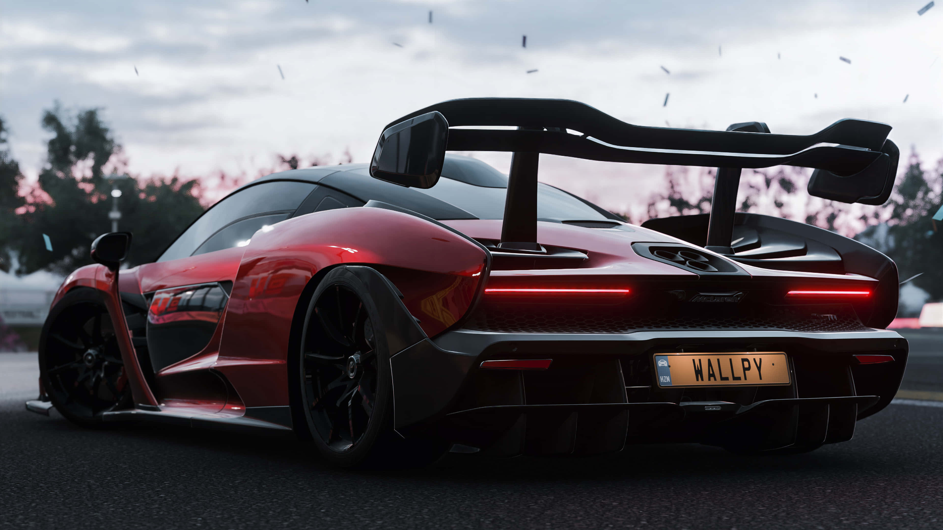 電玩遊戲 桌布 壁紙 — 一輛紅色McLaren Senna跑車，帶有發光的尾燈和大型後擾流板，停泊在黃昏時分的濕滑路面上。