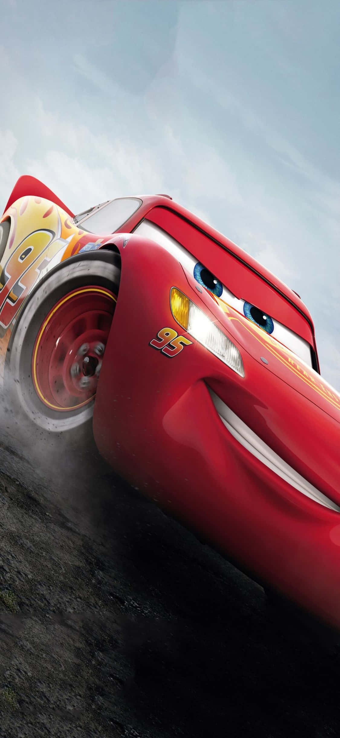 Lightning Mcqueen 桌布 壁紙 — 一輛紅色動畫賽車，有著表情豐富的眼睛和95號，在陰天下的塵土賽道上疾馳時微笑。