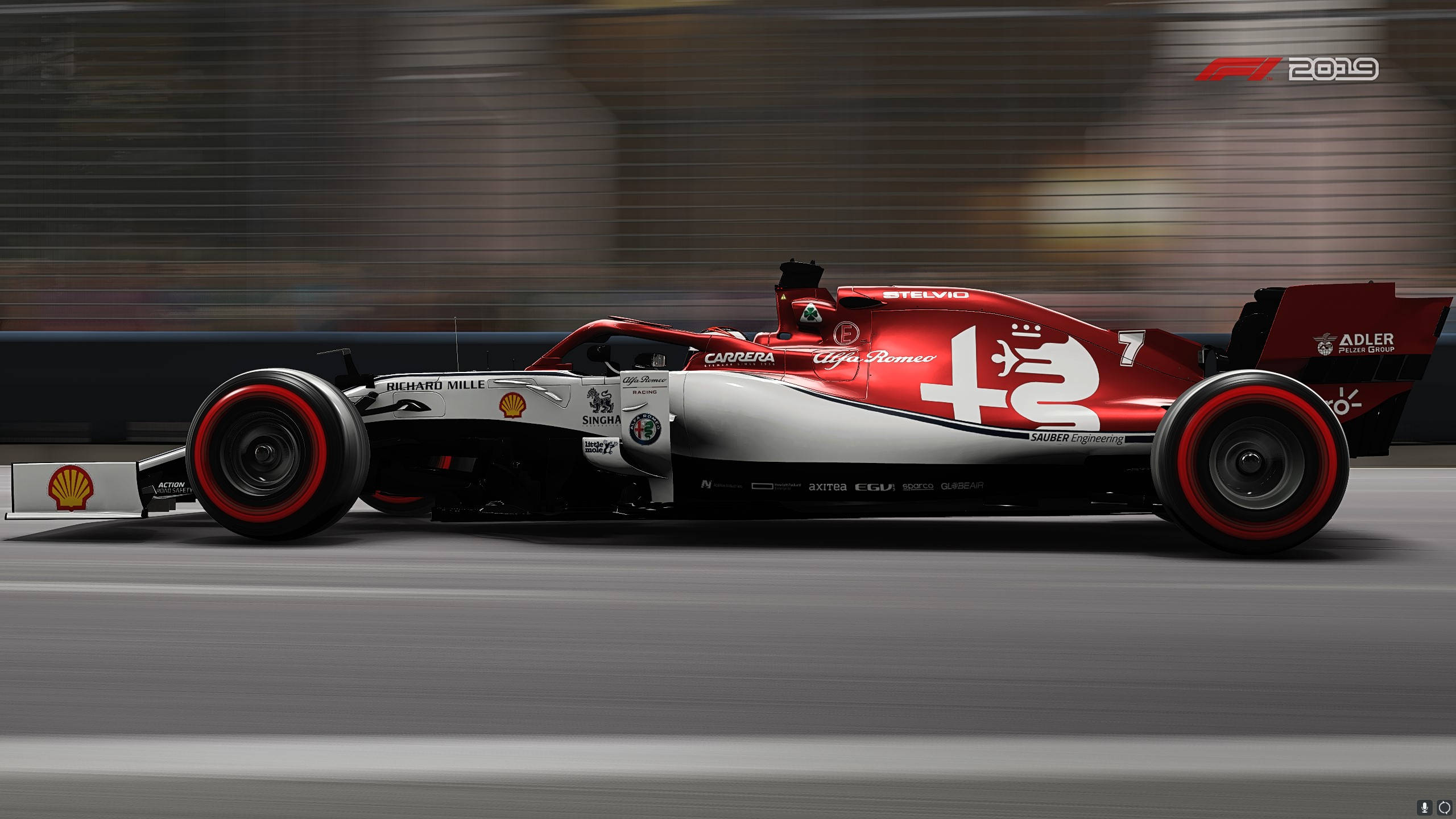 F1 2019 壁紙 桌布 壁紙 — 一輛紅色和銀色的愛快羅密歐一級方程式賽車在賽道上高速駛過，帶有動態模糊效果。