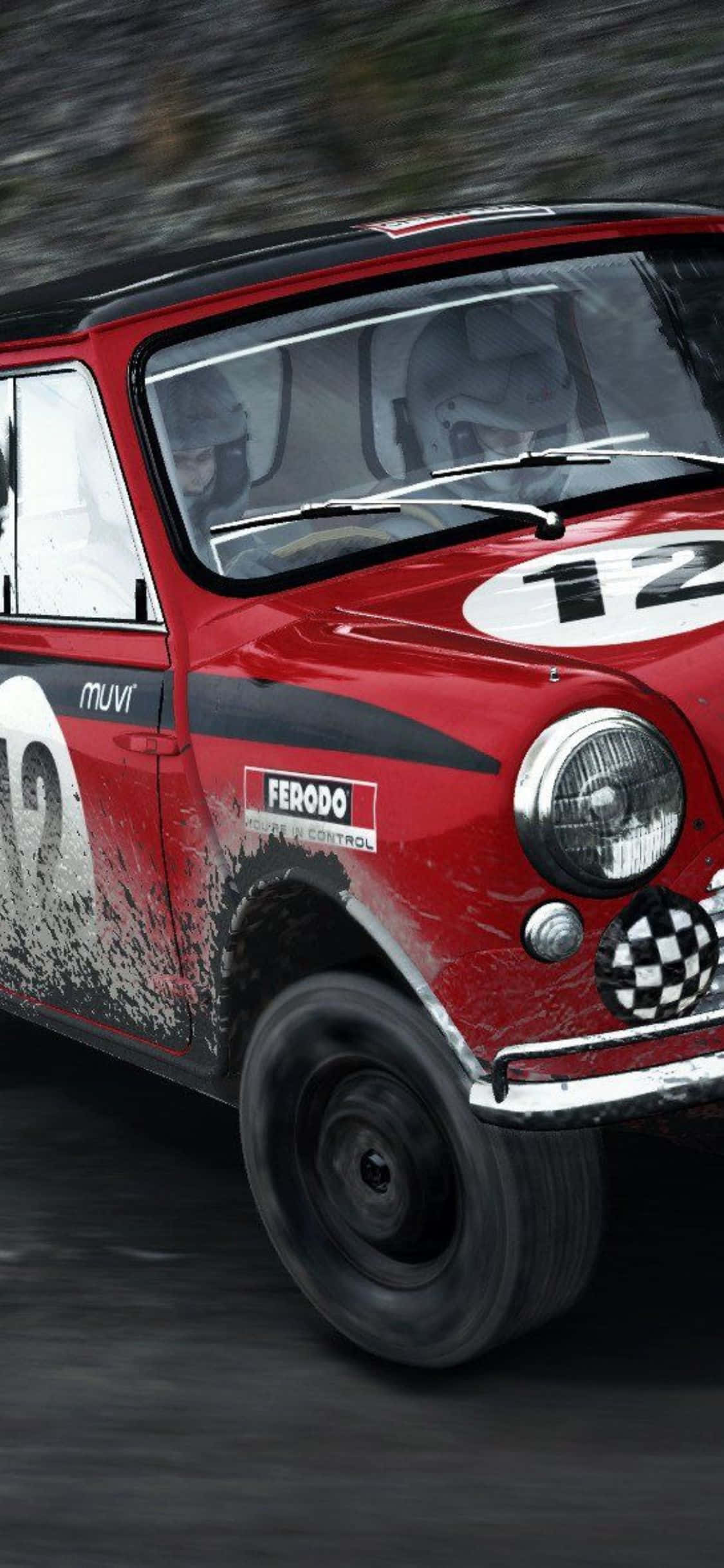 iPhone Xs Dirt Rally 桌布 壁紙 — 一輛紅色復古拉力賽車，車號12，在泥濘的森林賽道上疾馳，車手專注駕駛。
