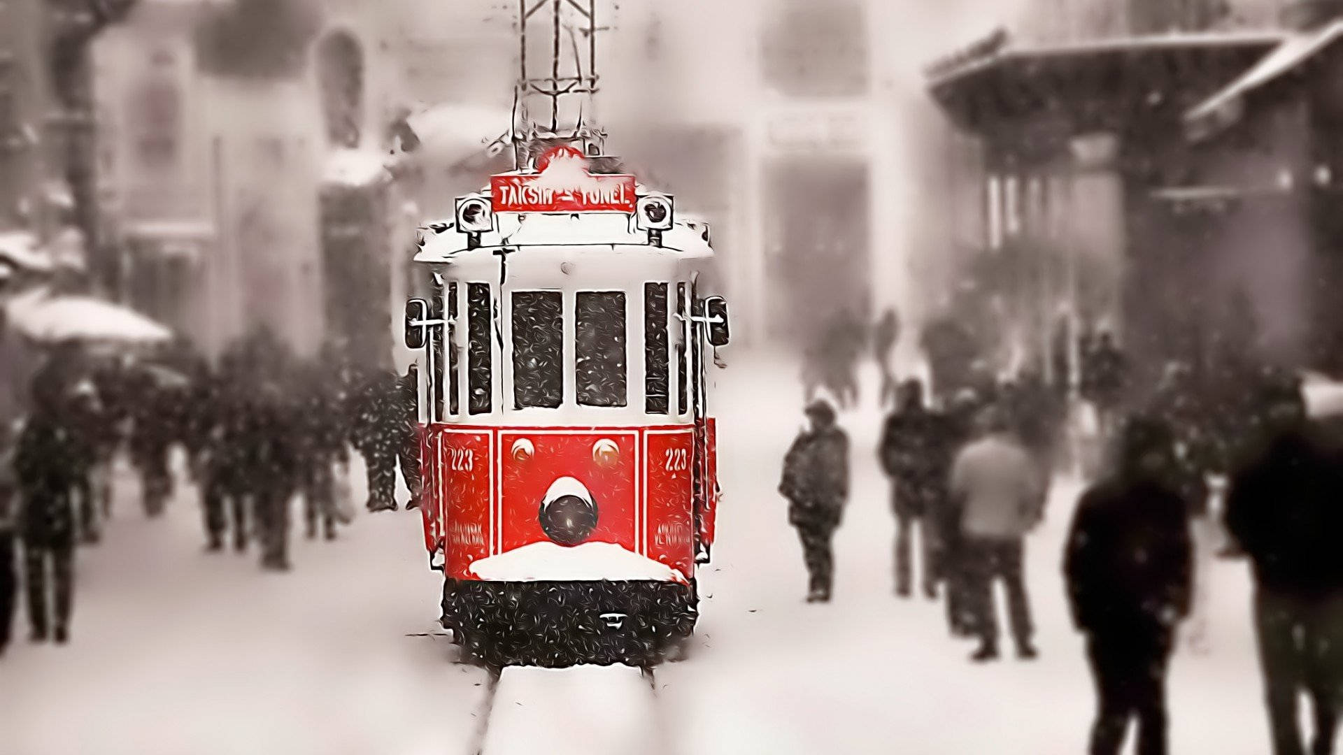 伊斯坦堡 桌布 壁紙 — 一輛紅色復古電車在積雪的市區街道上行駛，模糊的行人在飄落的雪中行走。