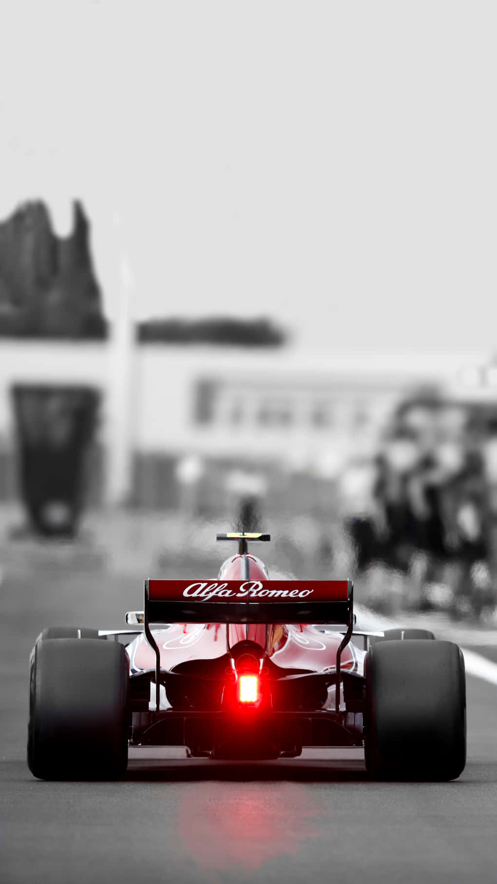 F1 2016 桌布 壁紙 — 一輛紅色愛快羅密歐一級方程式賽車的發光尾燈主導了單色賽道場景。