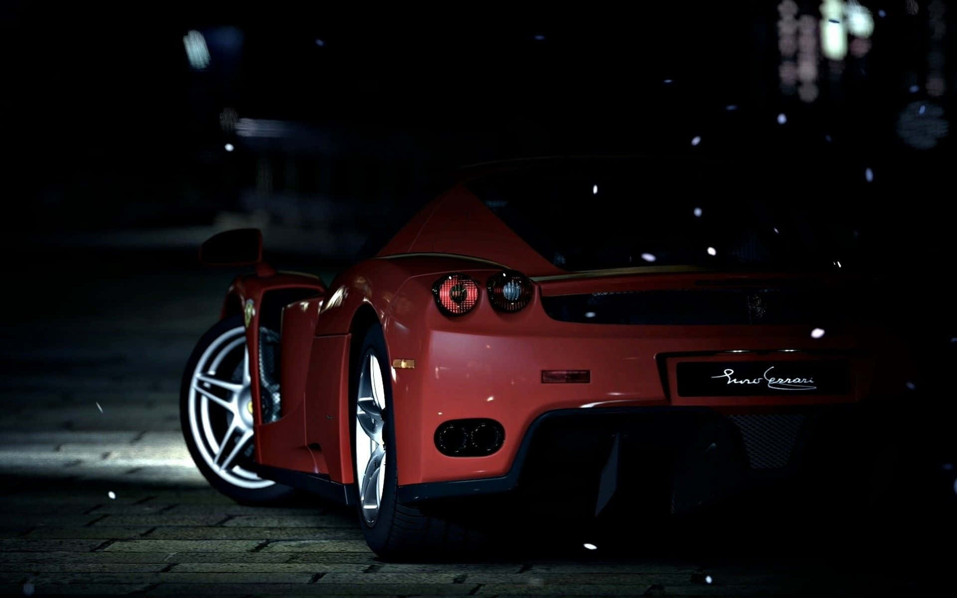 Ferrari Enzo 桌布 壁紙 — 一輛紅色法拉利Enzo在夜間濕滑的鵝卵石街道上，在飄雪中於聚光燈下閃耀。
