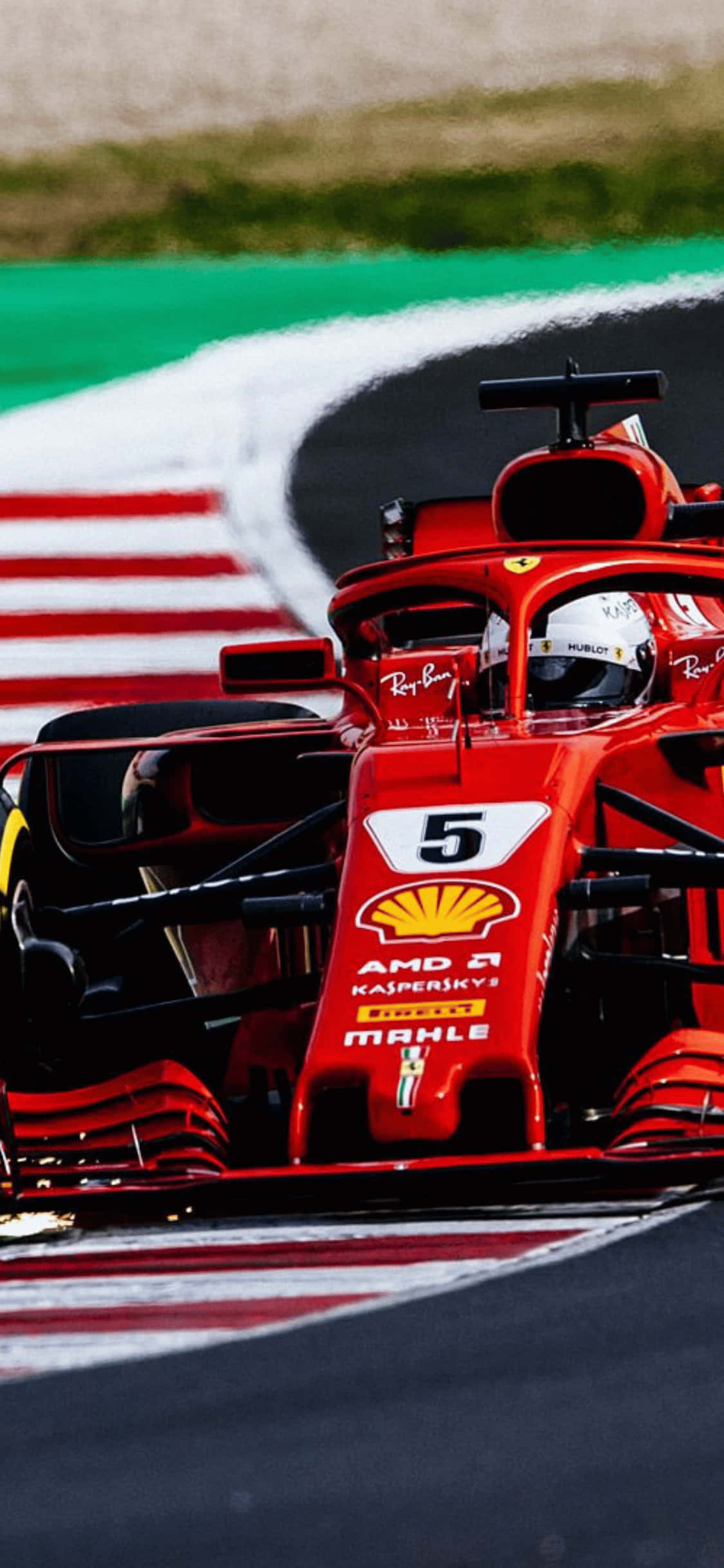 F1 2018 桌布 壁紙 — 一輛紅色法拉利F1賽車，車號5，在由綠色和紅白路肩環繞的賽道上奔馳。
