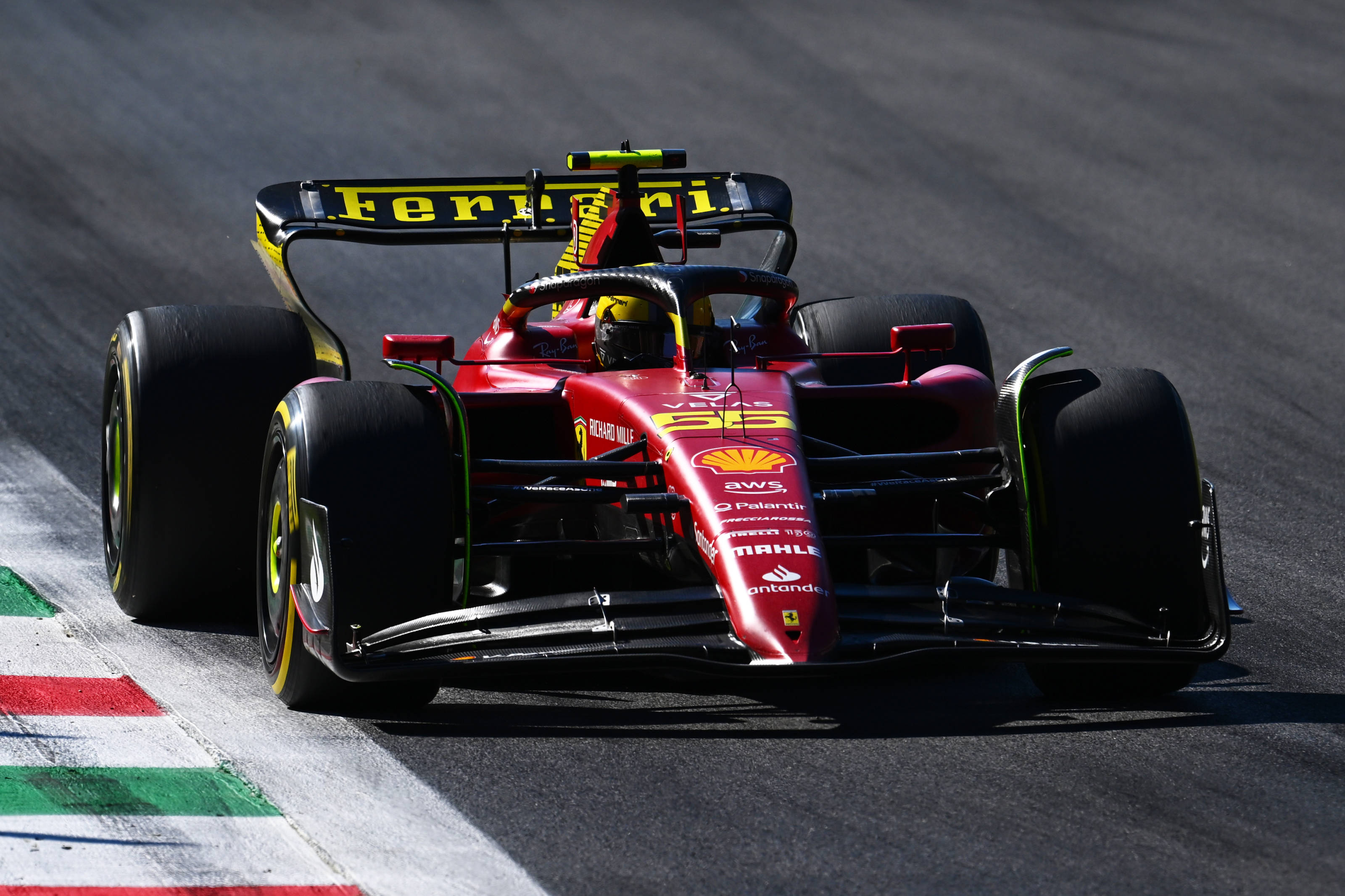 Racing 桌布 壁紙 — 一輛紅色法拉利F1賽車在明亮的日光下沿著帶有義大利國旗標記的賽道飛馳。