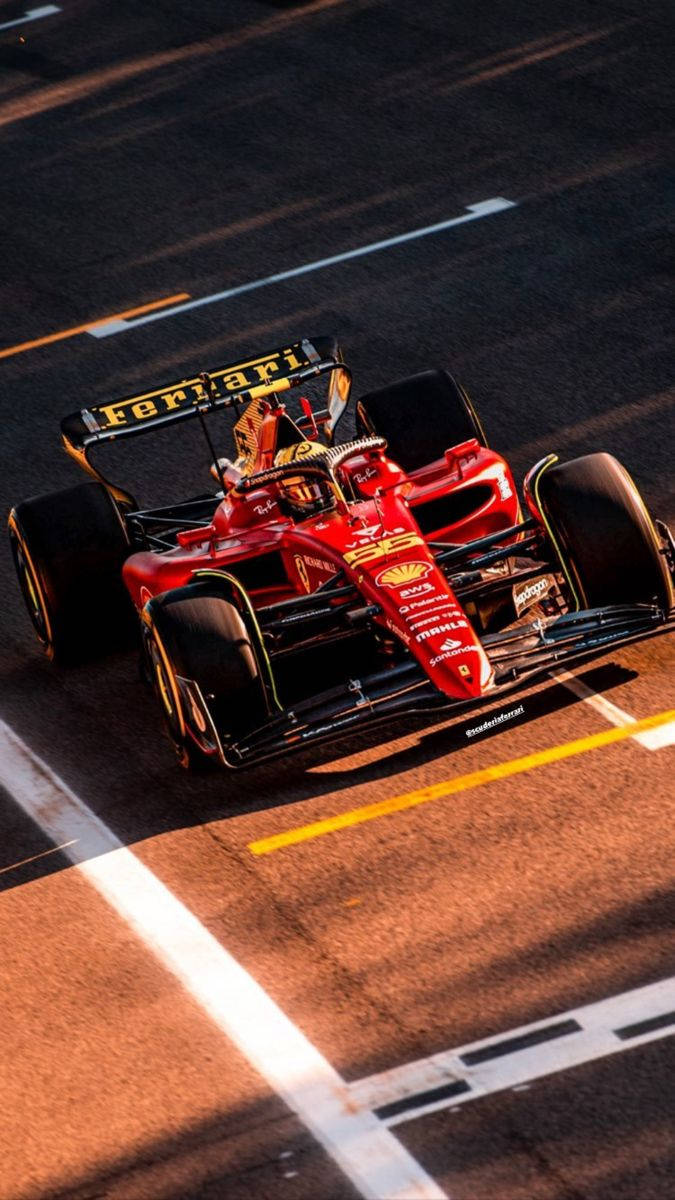 Racing 桌布 壁紙 — 一輛紅色法拉利F1賽車在陽光普照的賽道上奔馳，賽道上有醒目的黃色和白色車道標記。