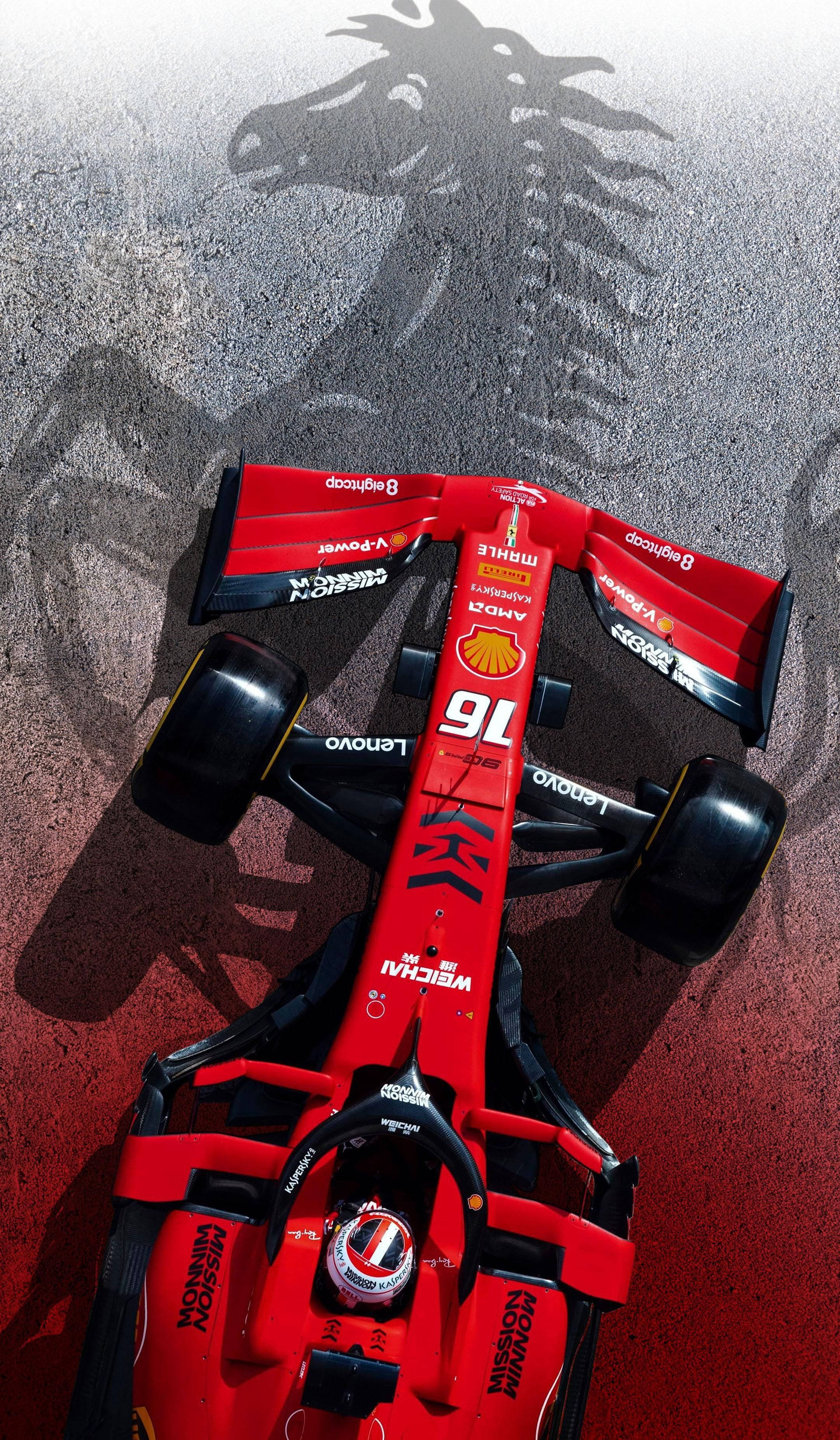 F1 桌布 壁紙 — 一輛紅色法拉利一級方程式賽車，號碼76，從上方俯瞰在賽道上投射出一個巨大的躍馬影子。