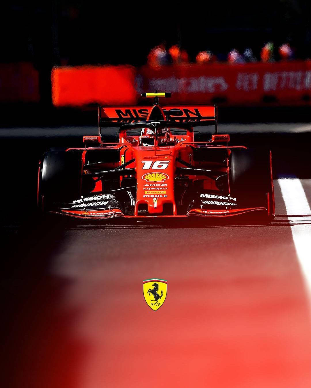 Racing 桌布 壁紙 — 一輛紅色法拉利一級方程式賽車，車號16，在夜間賽道燈光下行駛，背景是模糊的人群。