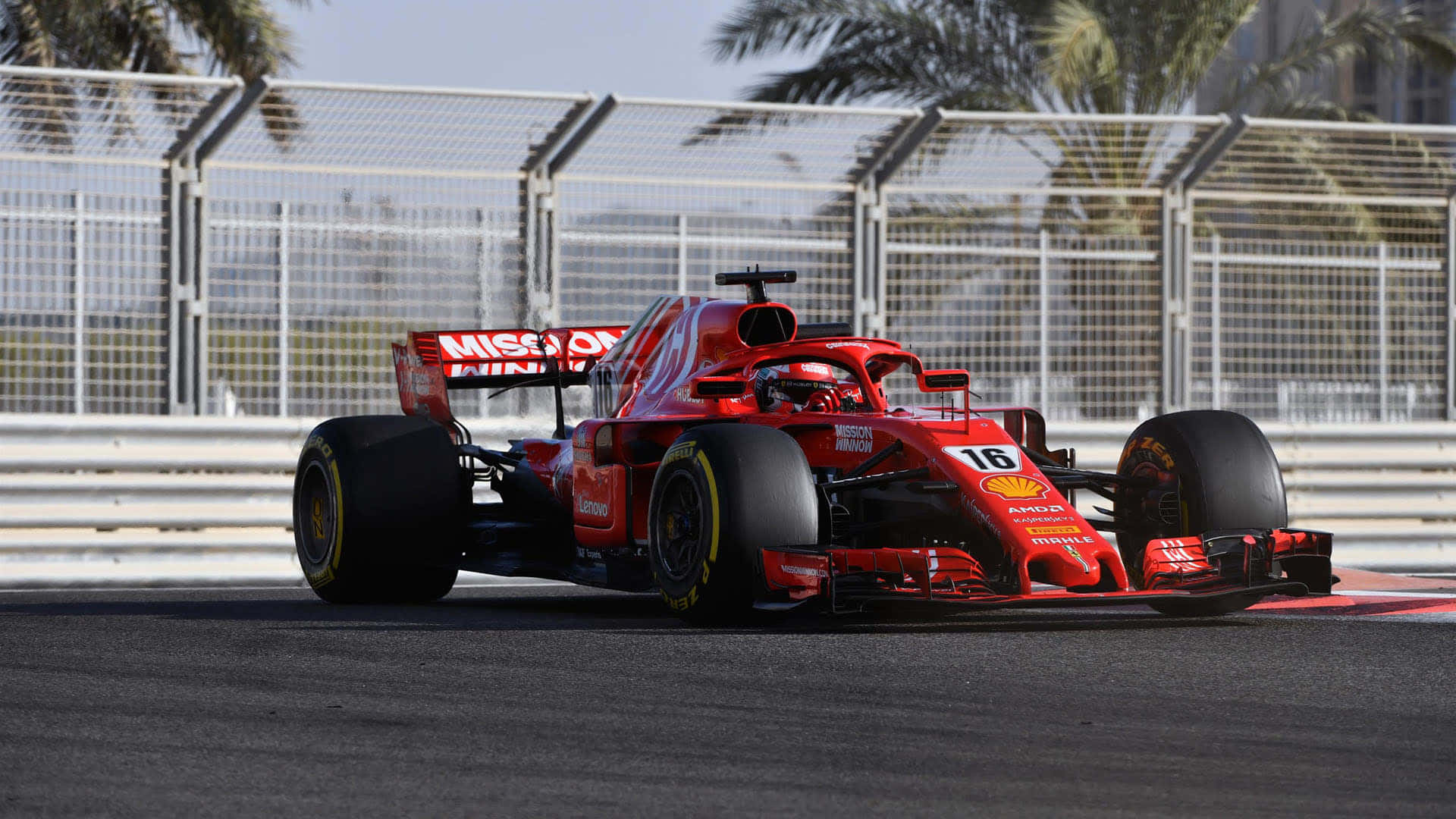 Formula One 桌布 壁紙 — 一輛紅色法拉利一級方程式賽車，車號16，在陽光明媚的賽道上奔馳，賽道兩旁種有棕櫚樹和安全護欄。