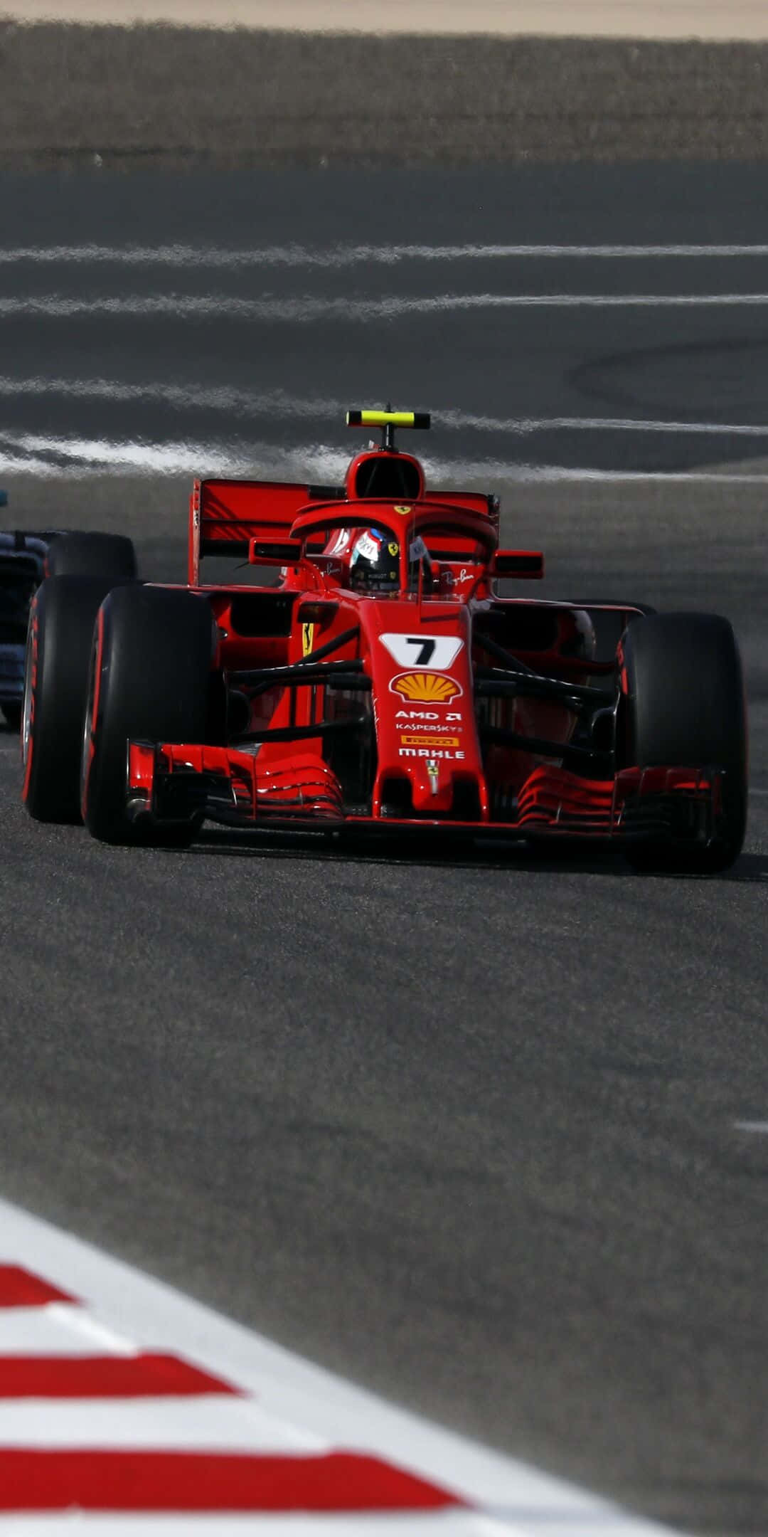 F1 桌布 壁紙 — 一輛紅色法拉利一級方程式賽車，車號7，在設有白色和紅色路緣的賽道上奔馳。