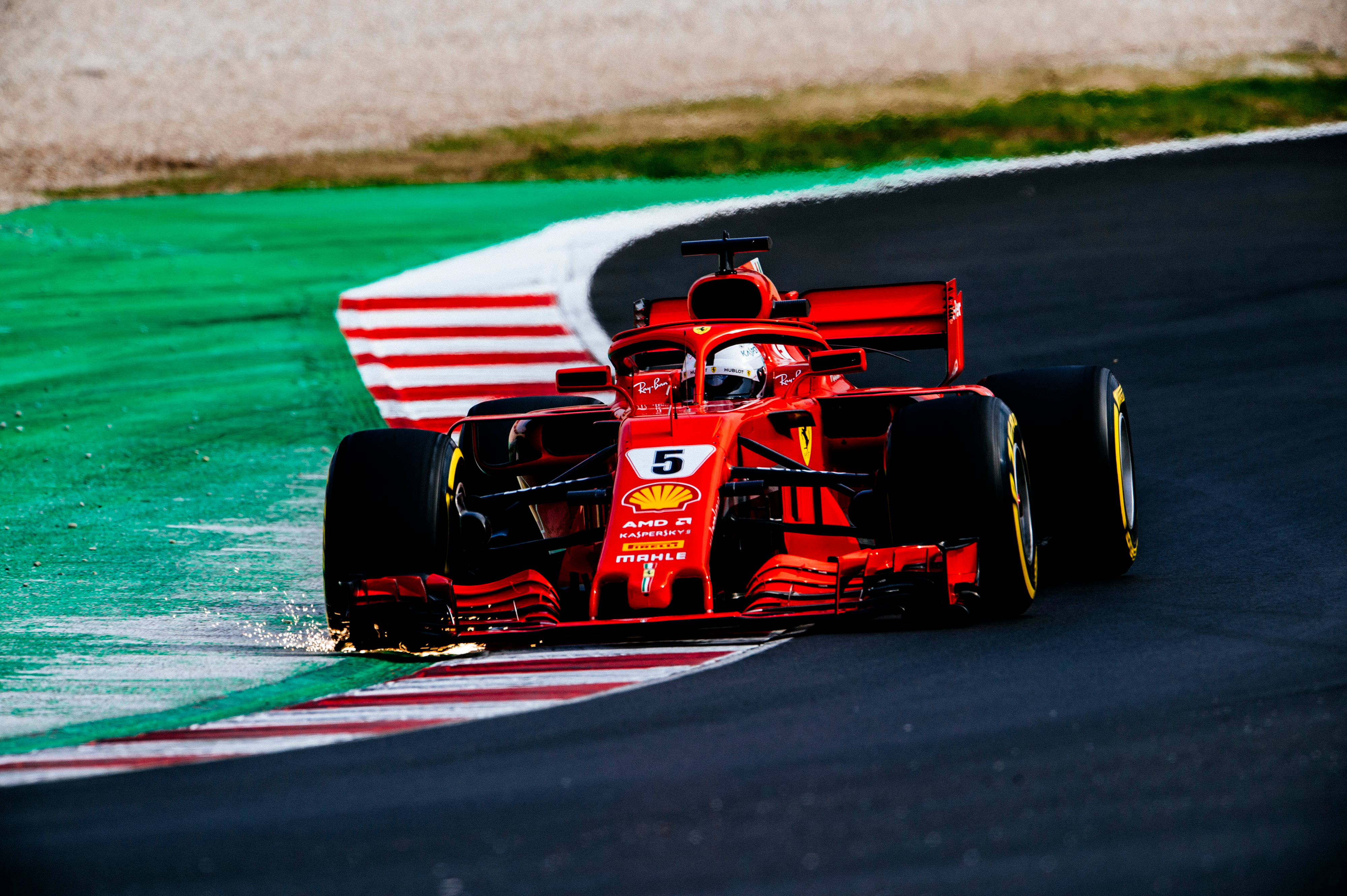 ferrari f1 2018 桌布 壁紙 — 一輛紅色法拉利一級方程式賽車，車號5，在潮濕的賽道彎道上緊貼行駛，濺起水花。