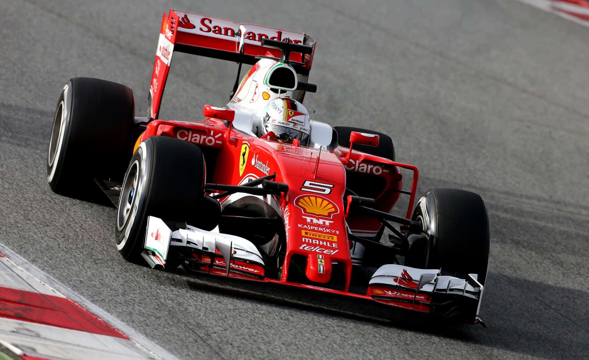 HD F1 2016 桌布 壁紙 — 一輛紅色法拉利一級方程式賽車，車號5，在賽道上疾馳，可見贊助商標誌和戴頭盔的車手。