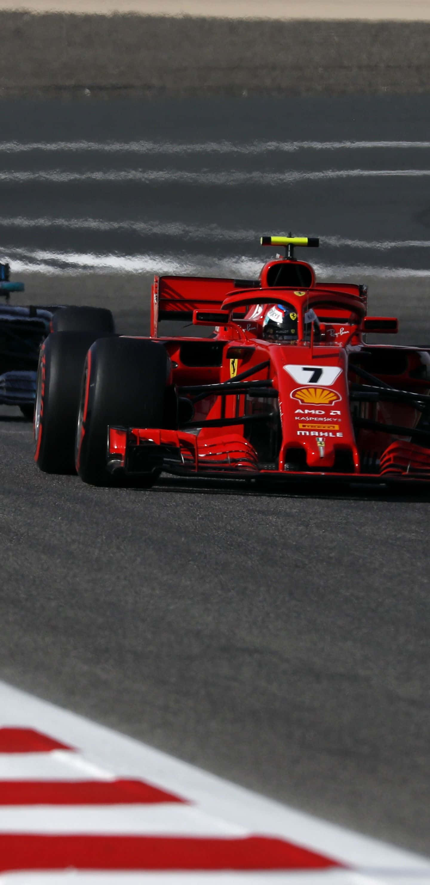 Formula 1 桌布 壁紙 — 一輛紅色法拉利一級方程式賽車，車號7，在帶有白色路緣和輪胎痕的賽道上奔馳。