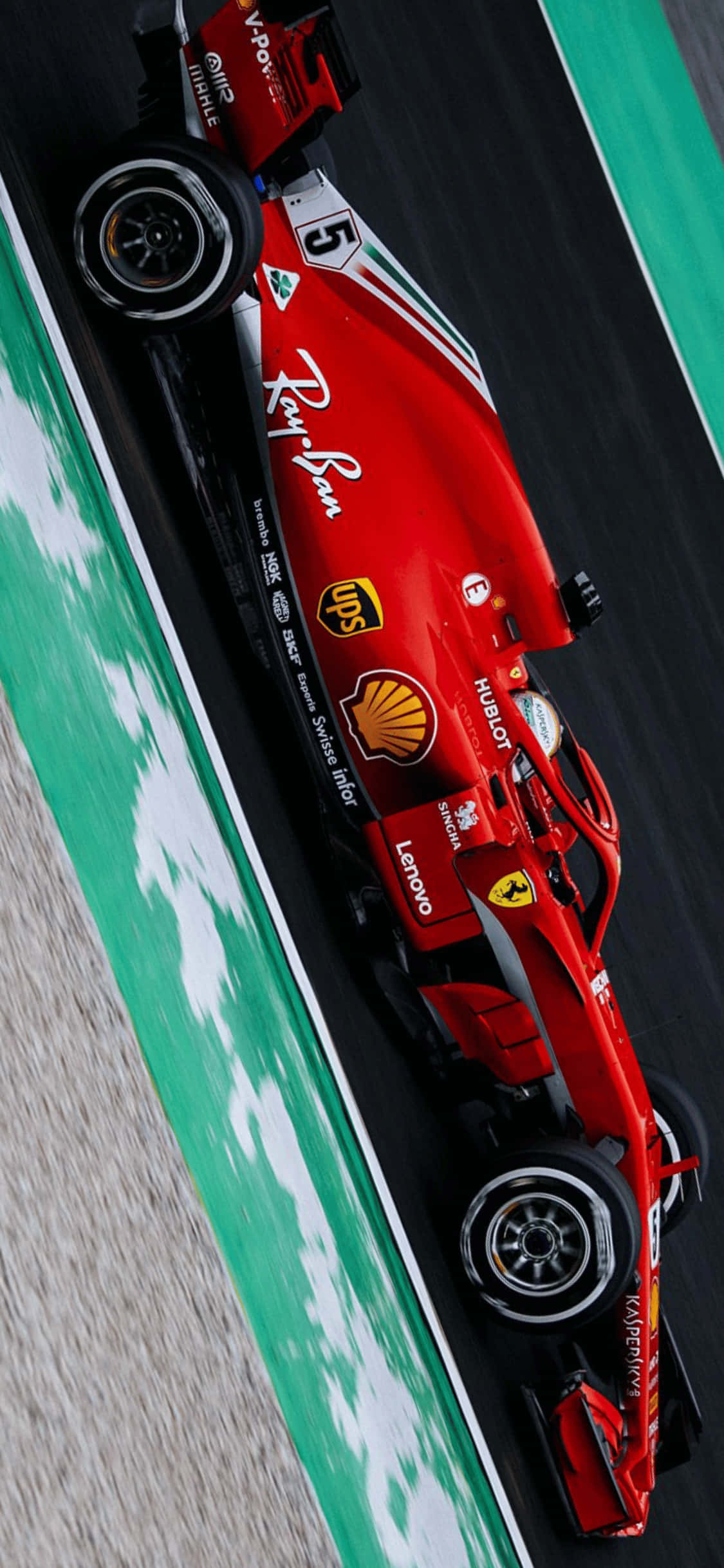 F1 2018 桌布 壁紙 — 一輛紅色法拉利一級方程式賽車在明亮的日光下，沿著帶有綠色和白色路緣的賽道飛馳。